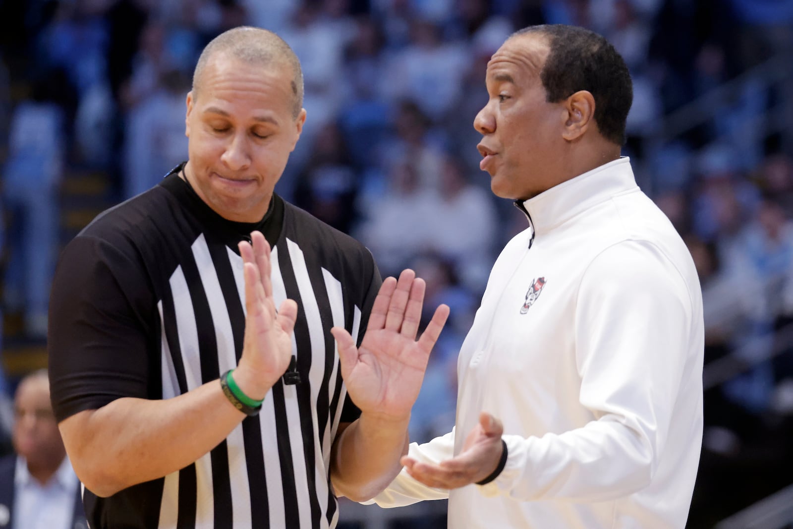 North Carolina State head coach Kevin Keatts, right, discusses a call with an official during the first half of an NCAA college basketball game, Wednesday, Feb. 19, 2025, in Chapel Hill, N.C. (AP Photo/Chris Seward)