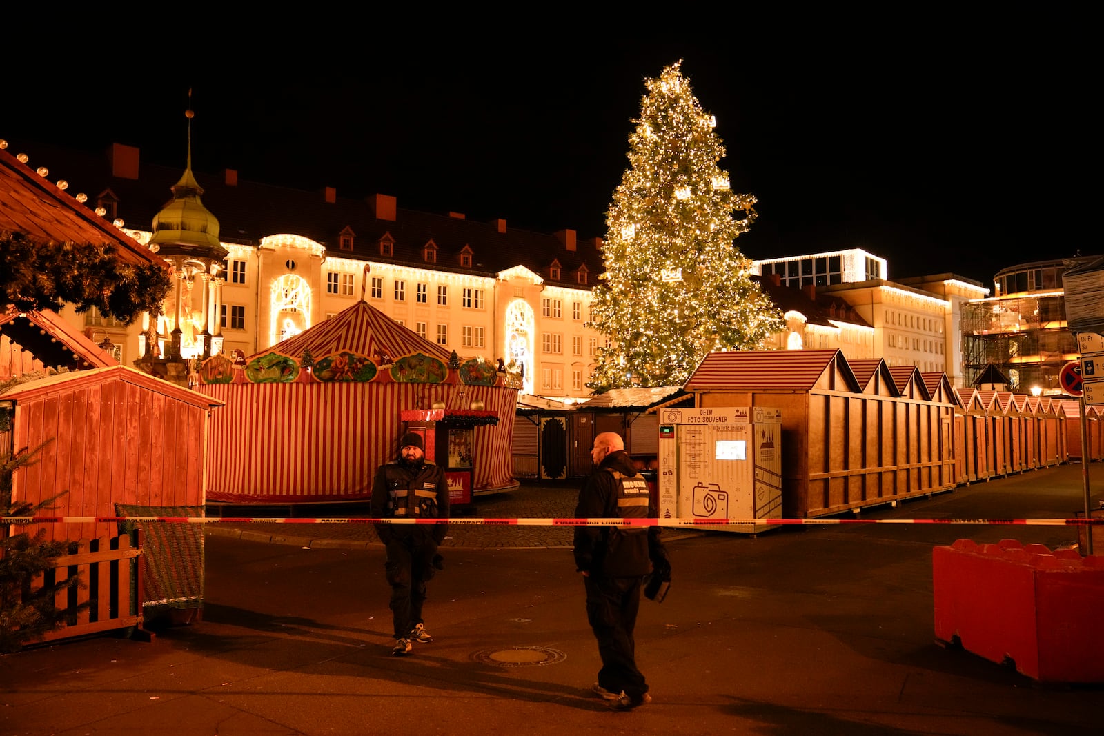 Security guards stand in front of a cordoned-off Christmas Market after a car crashed into a crowd of people, in Magdeburg, Germany, Saturday, Dec. 21, 2024. (AP Photo/Ebrahim Noroozi)