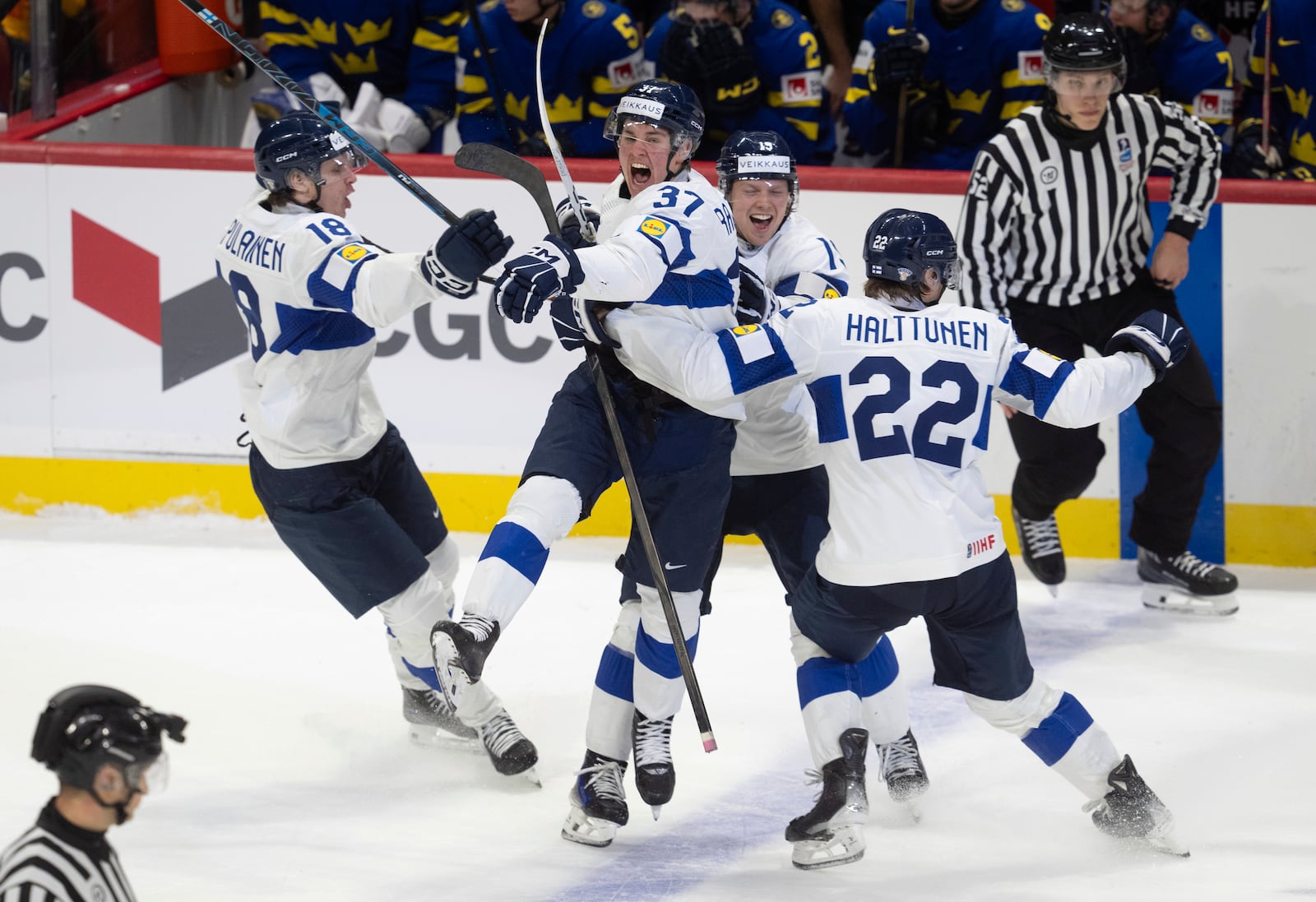 Finlands Benjamin Rautiainen (37) celebrates with teammates Rasmus Kumpulainen (18), Kasper Halttunen (22) and Konsta Helenius after scoring the game winning goal in overtime against Sweden in a semifinal game at the world junior hockey championship, Saturday, Jan. 4, 2025 in Ottawa, Ontario. (Adrian Wyld/The Canadian Press via AP)