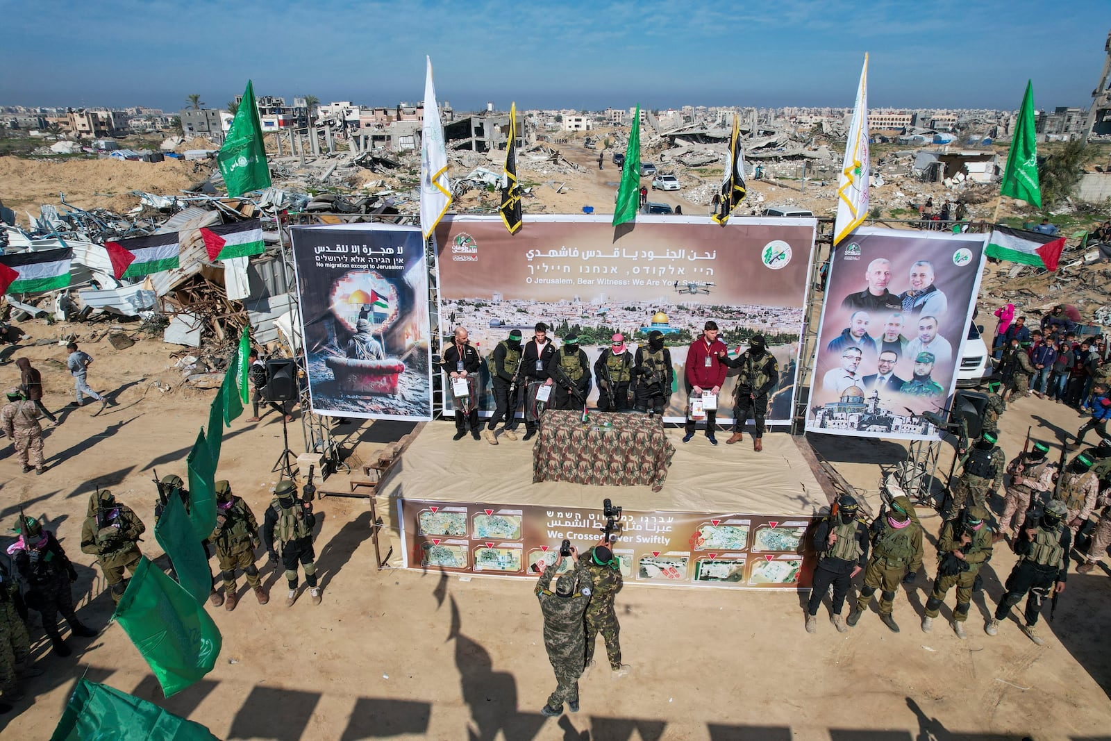 Israeli hostages Iair Horn, 46, left, Sagui Dekel Chen, 36, center left, and Alexander Troufanov, 29, right, are escorted by Hamas and islamic Jihad fighters on a stage before being handed over to the Red Cross in Khan Younis, Gaza Strip, Saturday, Feb. 15, 2025.