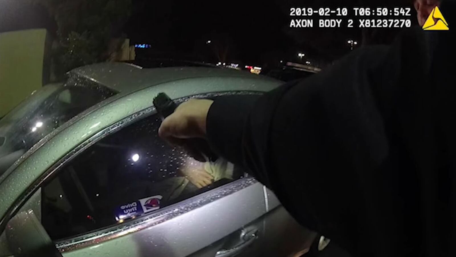 A Vallejo, California, police officer is seen pointing a gun at Willie McCoy, 20, as he sits asleep in his silver Mercedes in the drive-thru of a Taco Bell the night of Feb. 9, 2019. Six officers opened fire on McCoy, an aspiring rapper, moments after McCoy, who is seen scratching his shoulder in his sleep,  awoke and leaned forward. The officers said he reached for a gun in his lap.