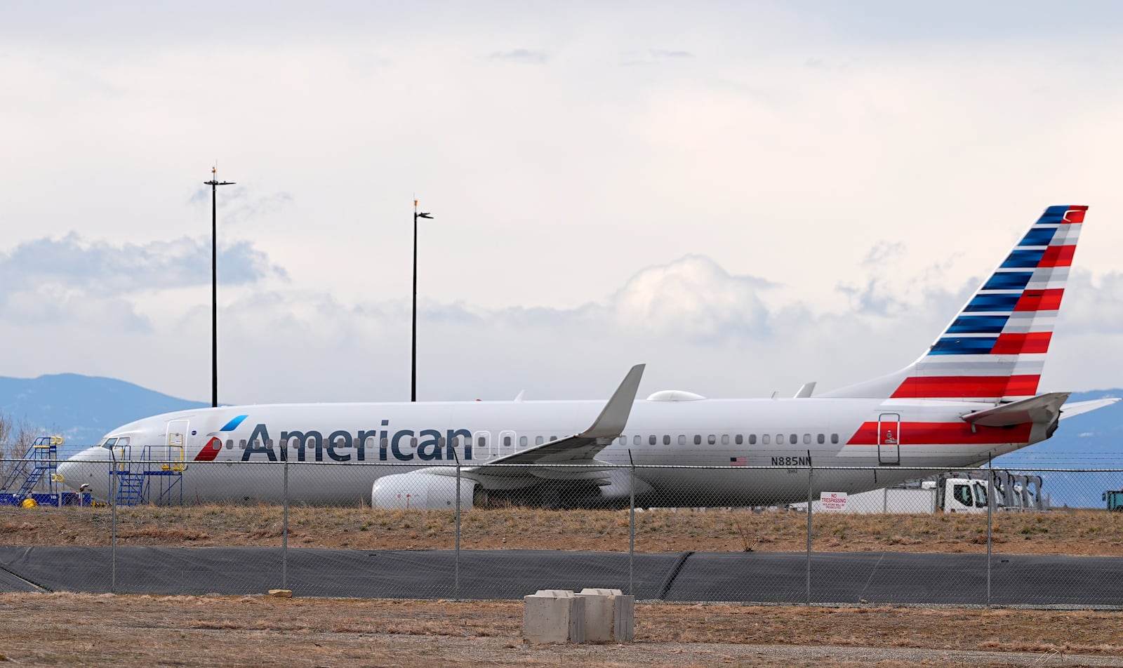 An American Airlines jetliner that caught fire after landing Thursday at Denver International Airport sits near a hangar at the airport Friday, March 14, 2025, in Denver. (AP Photo/David Zalubowski)