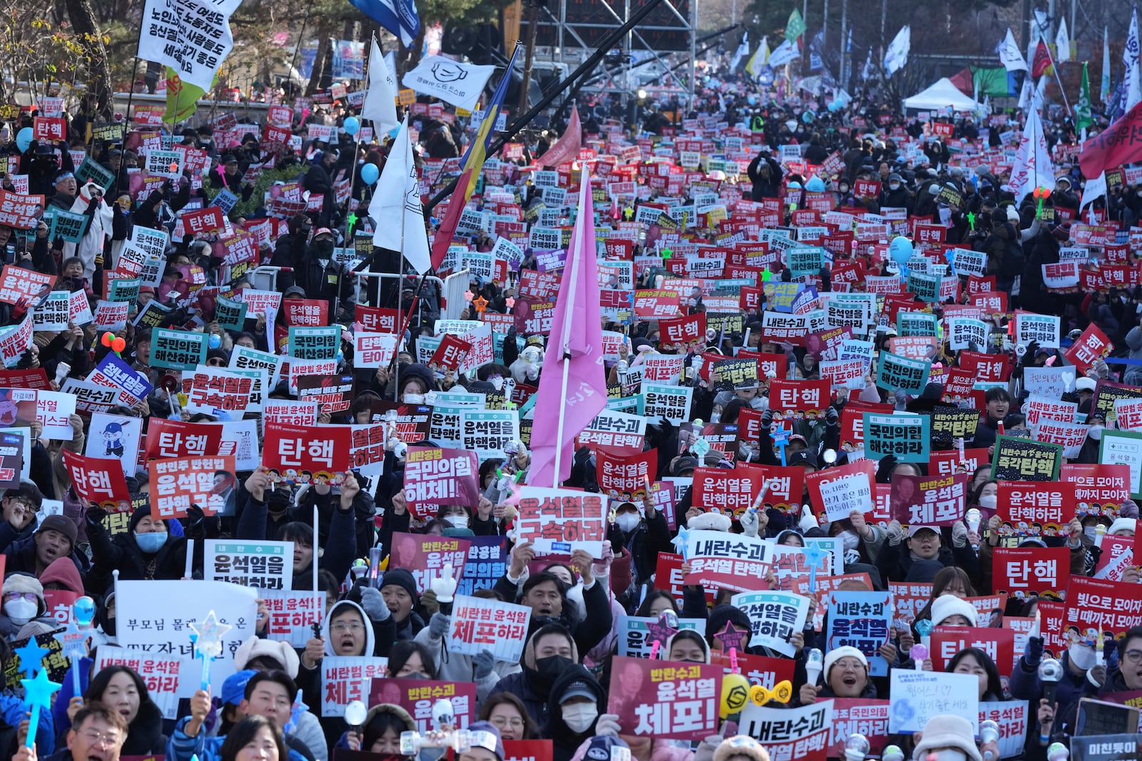 People hold signs before a rally to demand South Korean President Yoon Suk Yeol's impeachment outside the National Assembly in Seoul, South Korea, Saturday, Dec. 14, 2024. The letters read "Impeachment." (AP Photo/Lee Jin-man)