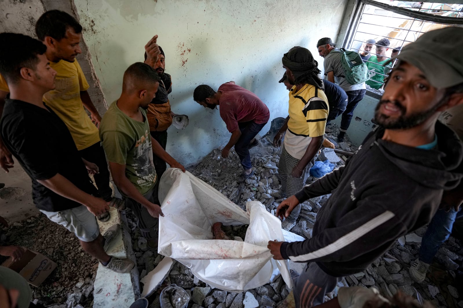 Palestinians search for the remains of their relatives killed in an Israeli bombardment of a school in Deir al-Balah, central Gaza Strip, Thursday, Oct. 10, 2024. (AP Photo/Abdel Kareem Hana)