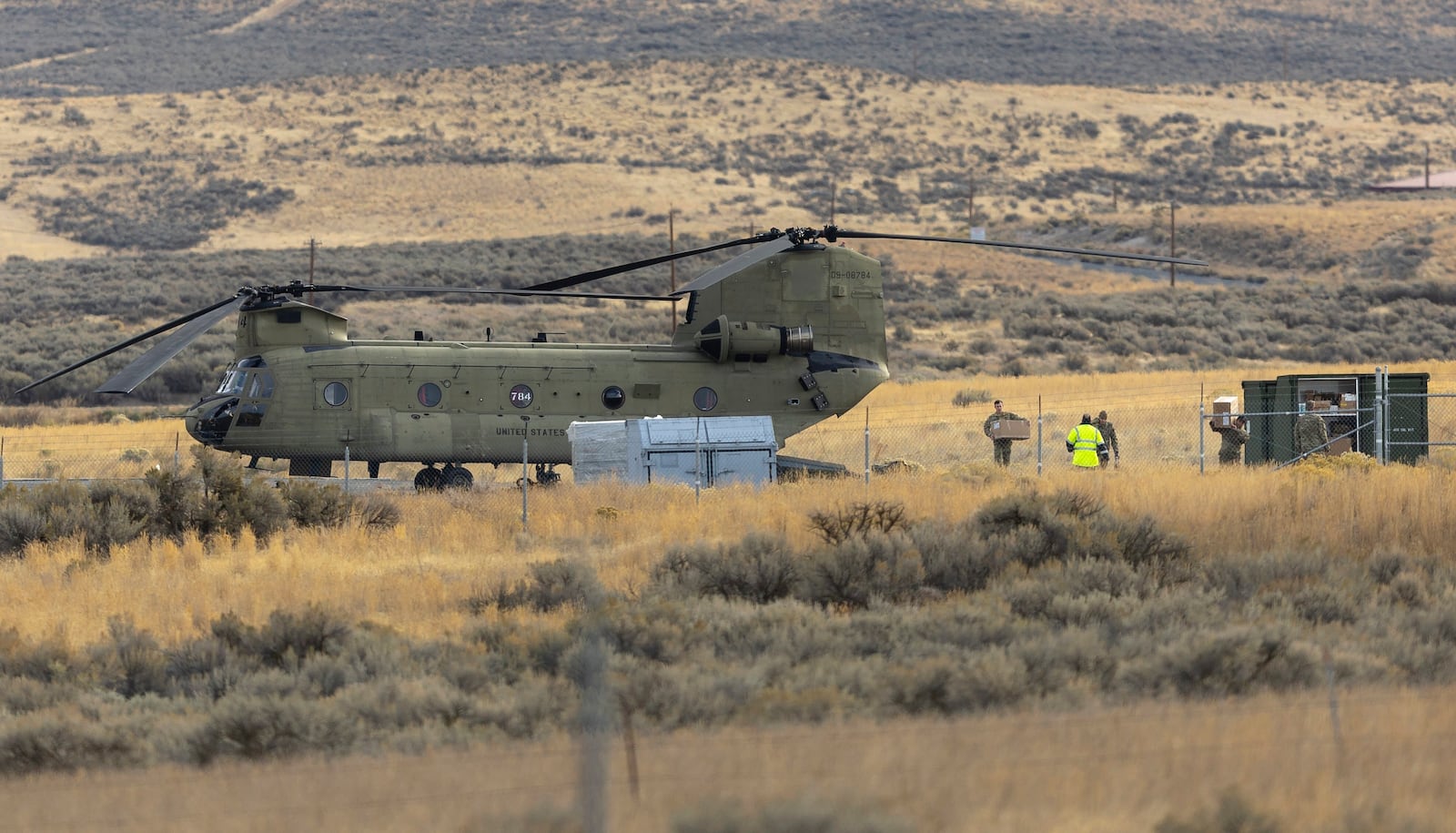 Crew members move boxes from a U.S. Army Chinook helicopter into a cargo container at Vagabond Army Heliport on Friday, Oct. 18, 2024, in Yakima, Wash. (Nick Wagner/The Seattle Times via AP)