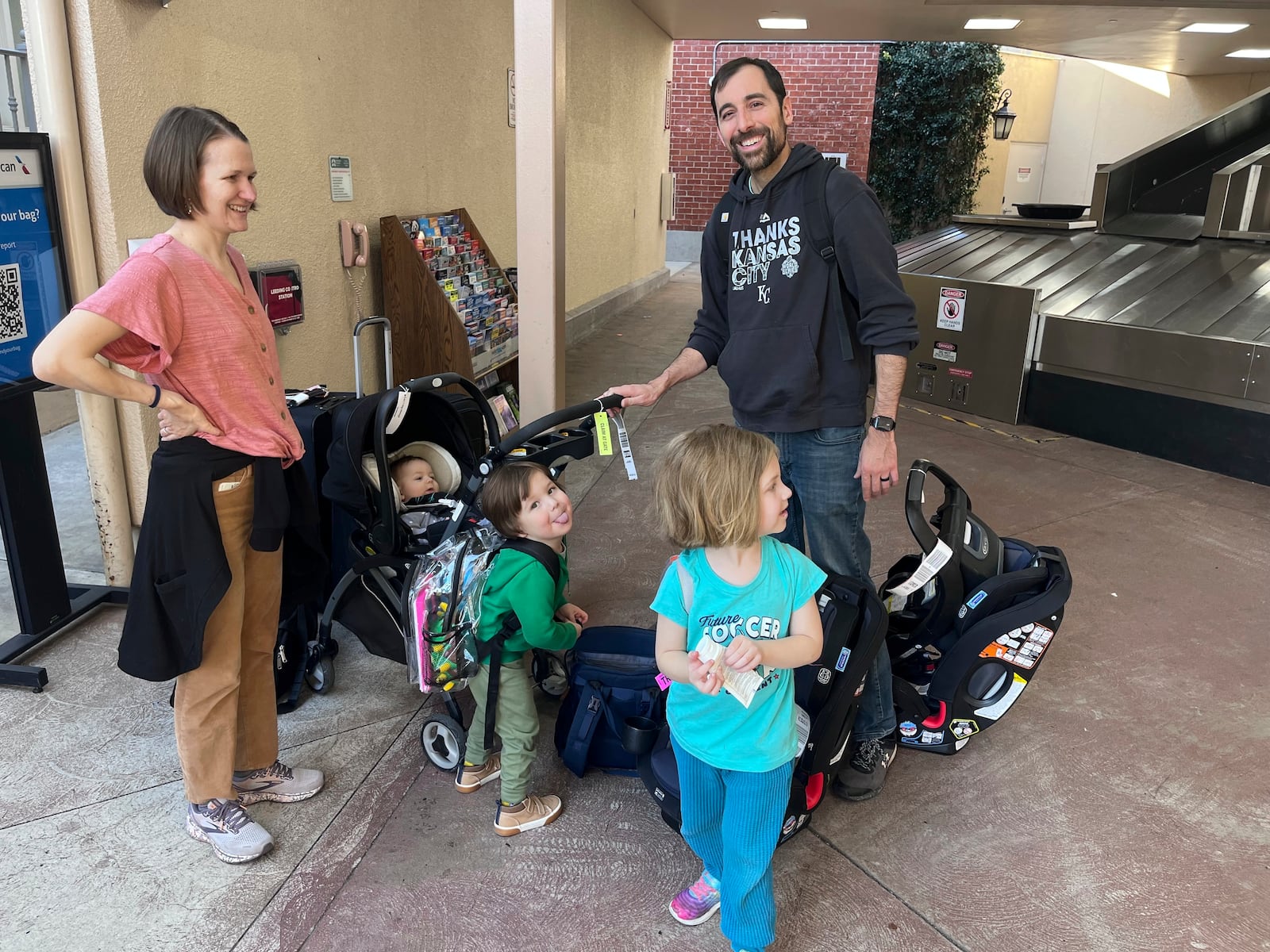 Andrea and Adam Arredondo stand their three kids, three car seats, stroller, and play set they travel with, after the family landed at the Burbank, Calif., airport on Thursday, Feb. 20, 2025. (AP Photo/Jaimie Ding)