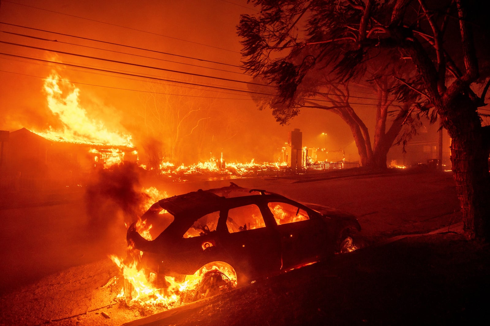 FILE - The Palisades Fire burns vehicles and structures in the Pacific Palisades neighborhood of Los Angeles, Jan. 7, 2025. (AP Photo/Ethan Swope, File)