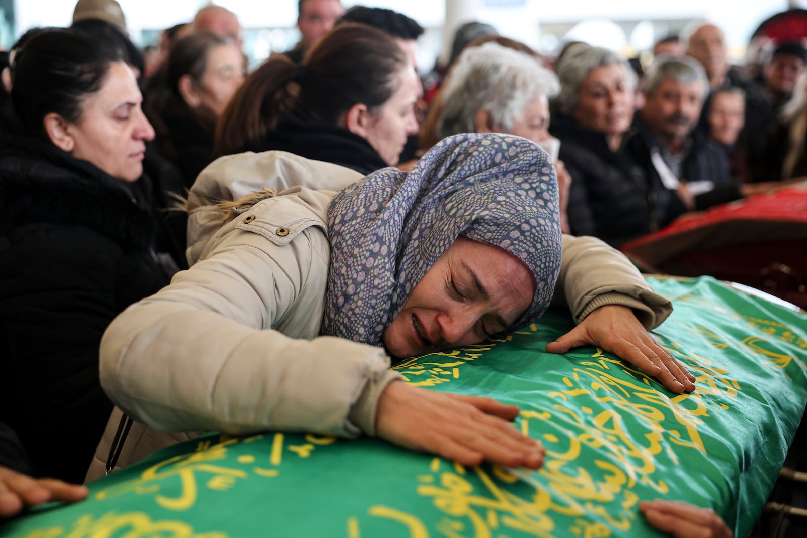 Relatives and friends mourn during the funeral of Yilmaz Saritas and his children Nehir and Doruk, who were among the 76 victims who died in a fire at the Kartalkaya ski resort in Bolu province, at Karsıyaka cemetery in Ankara, Wednesday, Jan. 22, 2025. (Ugur Yildirim/Dia Photo via AP)