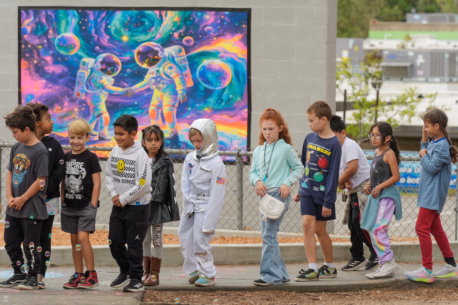 Santiago STEAM Magnet Elementary School students arrived dressed with space themed clothing at a ceremony to plant a small Giant Sequoia tree from NASA's Artemis I Mission's tree seeds that traveled around the moon twice, after the school was honored in the spring of 2024 to become NASA Moon Tree Stewards in Lake Forest, Calif., on Monday, Oct. 14, 2024. (AP Photo/Damian Dovarganes)