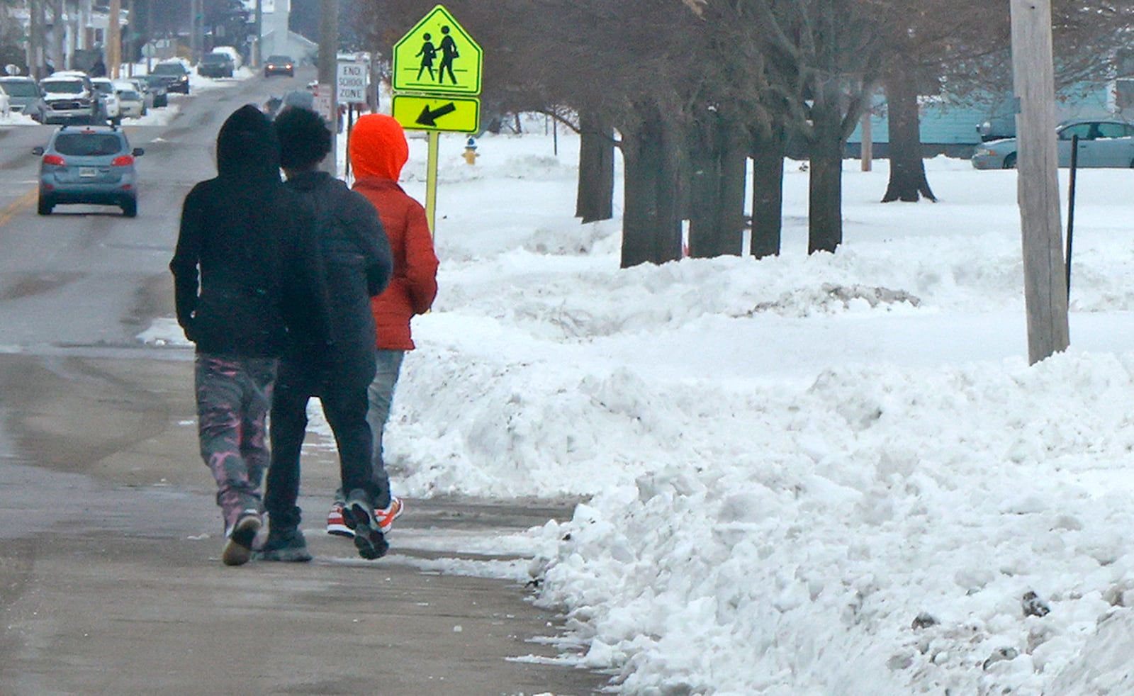 Three students walk Hayward Middle School in the roadway to avoid the snow covered sidewalk Wednesday, Jan. 8, 2025. BILL LACKEY/STAFF