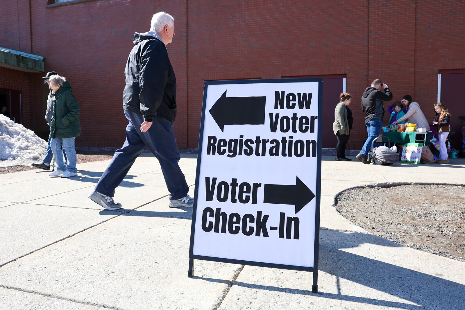 A sign for new voter registration is seen outside a polling location at Pinkerton Academy in Derry, N.H., Tuesday, March 11, 2025. (AP Photo/Reba Saldanha)