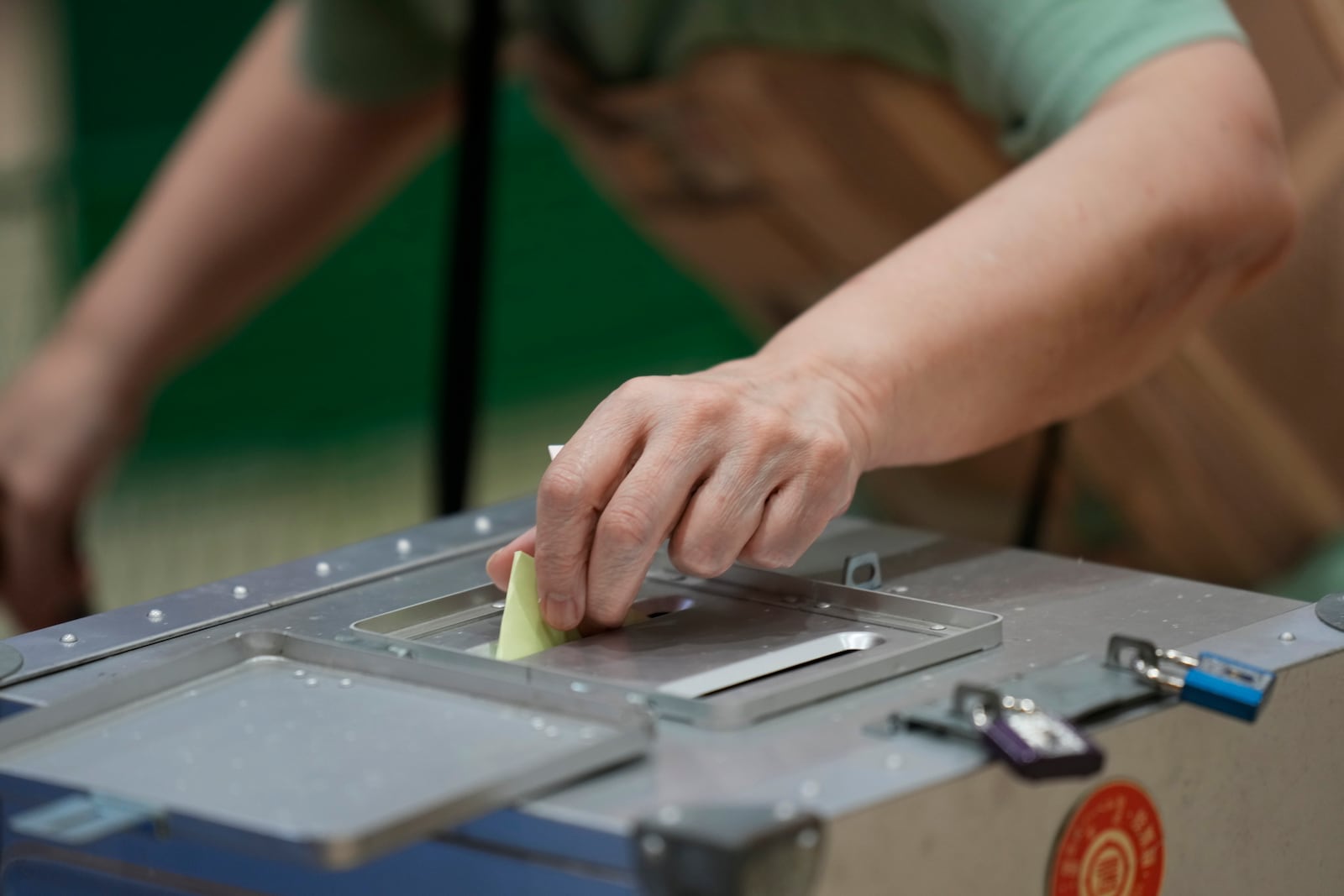 A voter casts her ballot at a polling station for Japan's lower house election in Tokyo, Japan, Sunday, Oct. 27, 2024. (AP Photo/Hiro Komae)