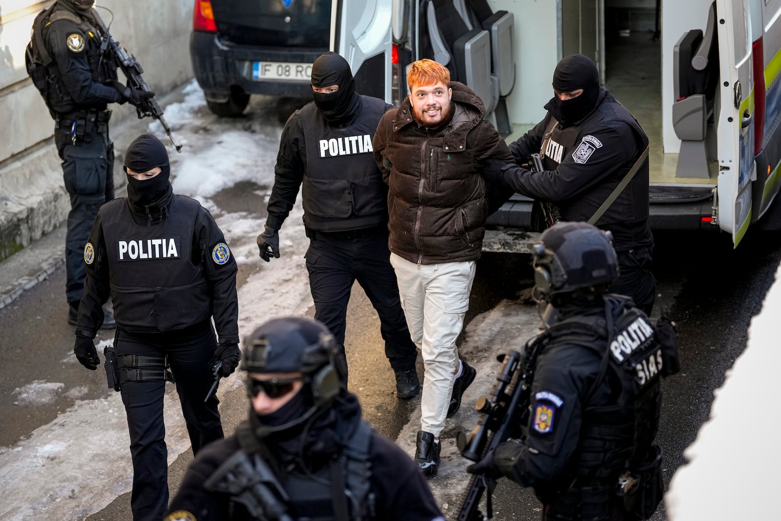 Mohamed Amra, nicknamed ''The Fly", is brought handcuffed by police officers at the Court of Appeals in Bucharest, Romania, Sunday, Feb. 23, 2025, following his arrest the day before. (AP Photo/Vadim Ghirda)