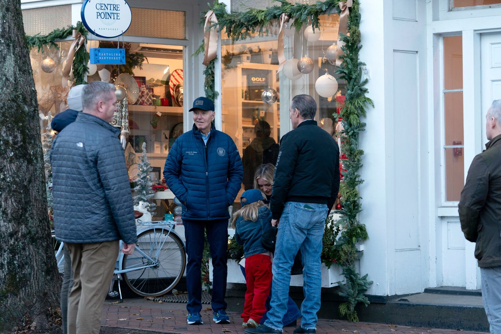 President Joe Biden, from center left, accompanied by his grandson Beau and son Hunter Biden, walk in downtown Nantucket, Mass., Friday, Nov. 29, 2024. (AP Photo/Jose Luis Magana)