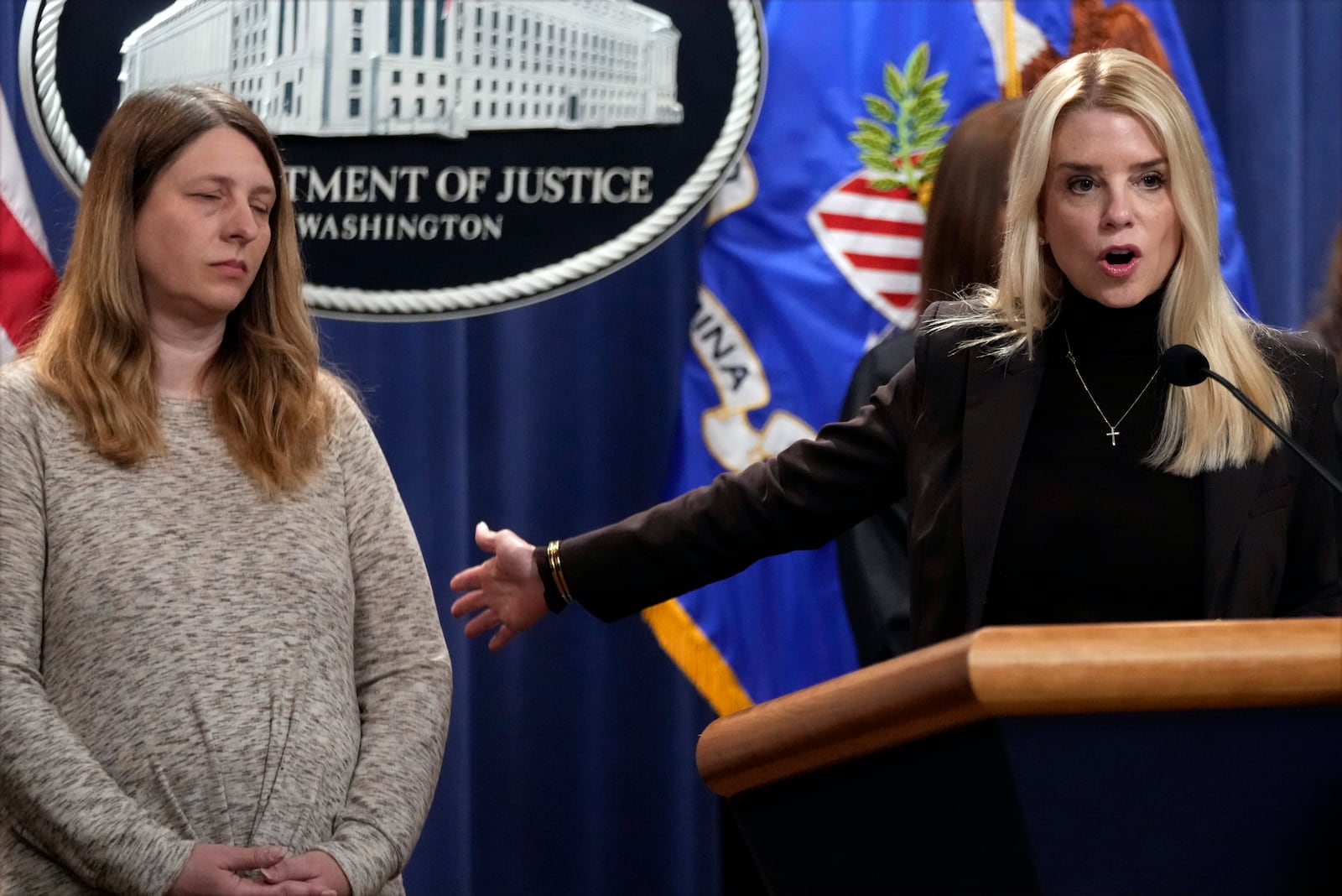 Attorney General Pam Bondi speaks at a news conference regarding immigration enforcement at the Justice Department, Wednesday, Feb. 12, 2025, in Washington, as Tammy Nobles, mother of Kayla Hamilton, listens. (AP Photo/Ben Curtis)