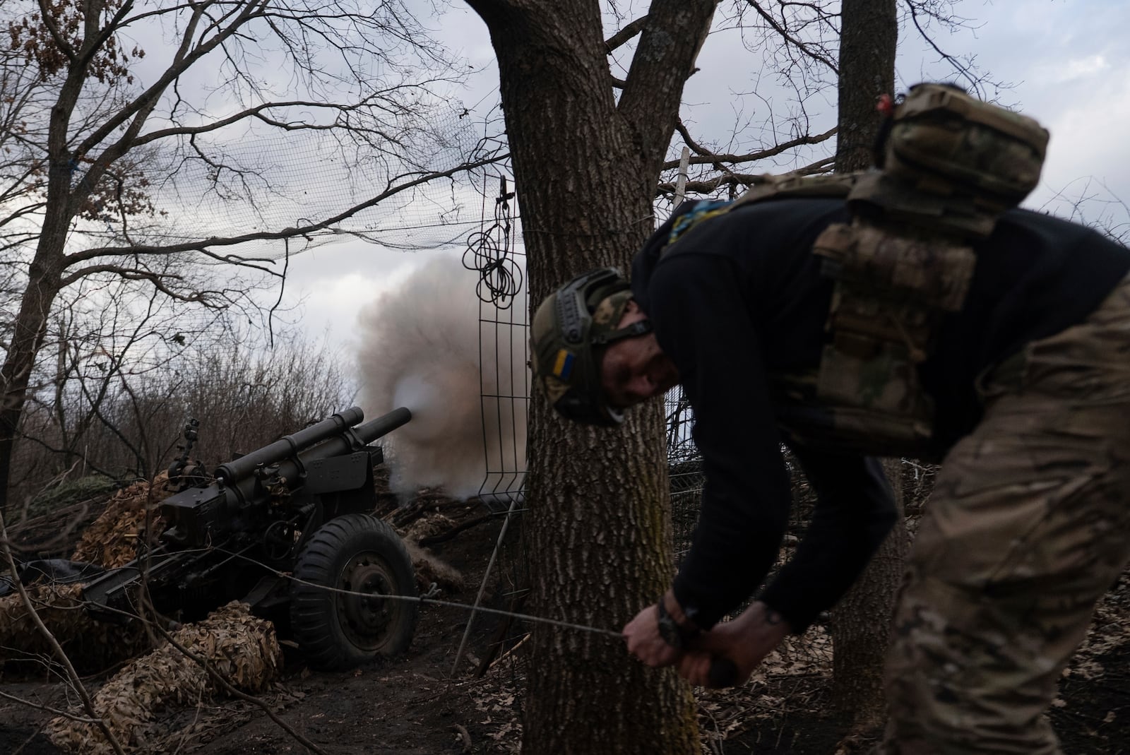 Ukrainian serviceman of Khartia brigade known by call sign "Krystal" fires M101 Howitzer towards Russian positions in Kharkiv region, Ukraine, Wednesday, March 12, 2025. (AP Photo/Alex Babenko)