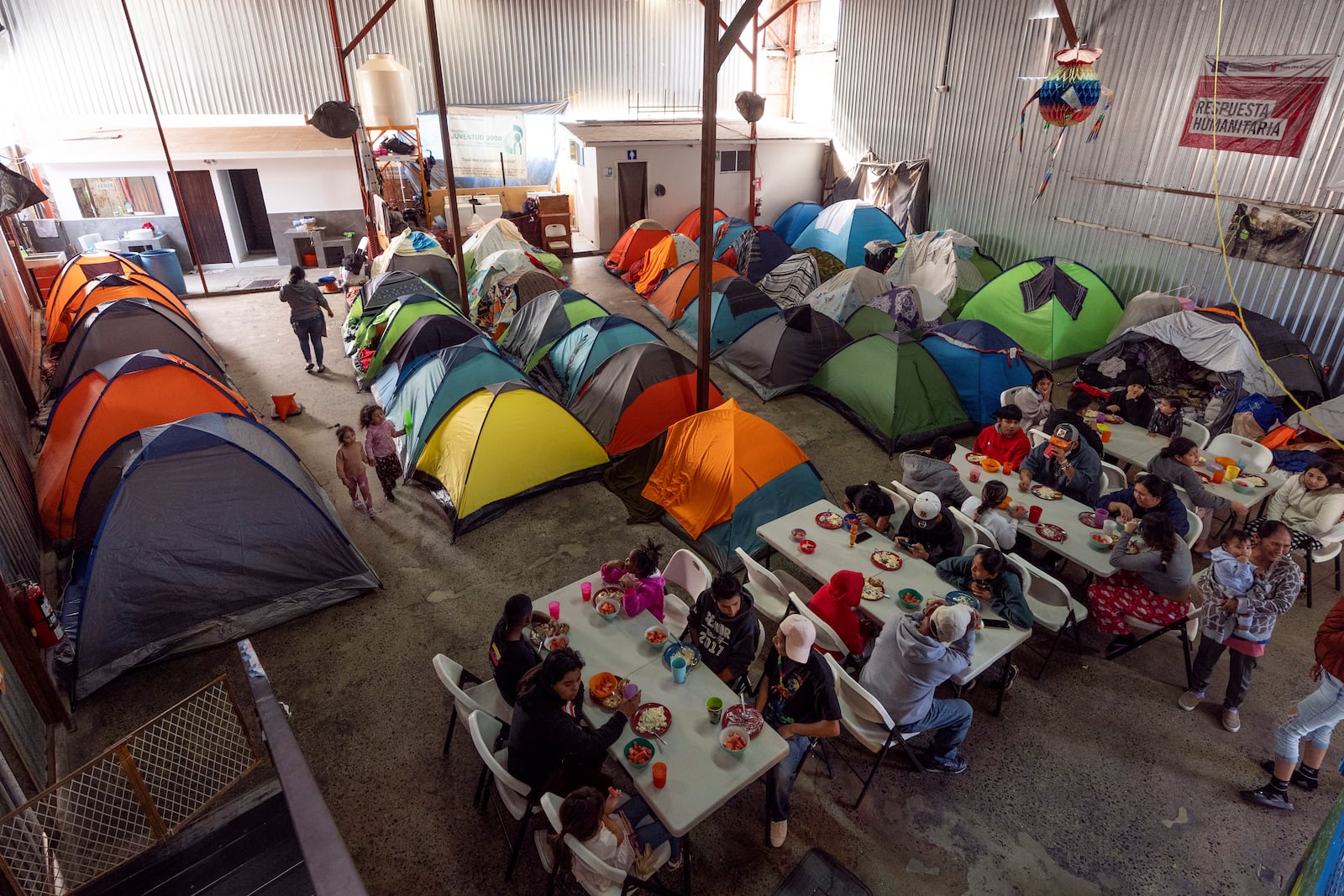 Migrants eat at a shelter Wednesday, Jan. 22, 2025, in the border city of Tijuana, Mexico. (AP Photo/Gregory Bull)