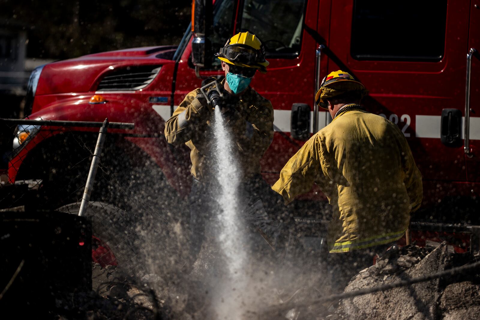 A Cal Fire engine crew with the Nevada-Yuba-Placer Unit hoses down a hotspot at a home destroyed by the Eaton Fire in Altadena, Calif., Sunday, Jan. 12, 2025. (Stephen Lam/San Francisco Chronicle via AP)