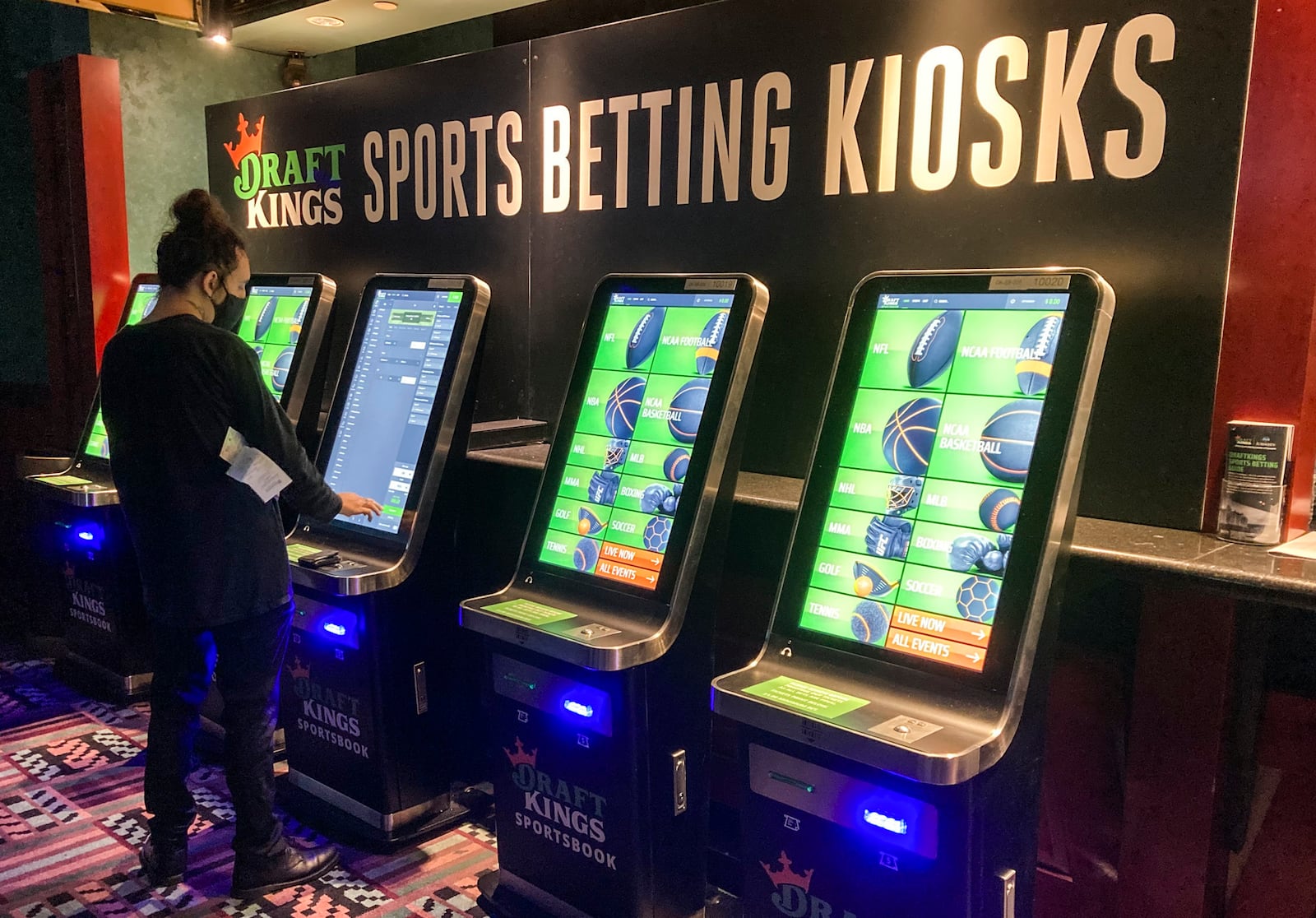 FILE - In this Thursday Sept. 30, 2021, file photo Zach Young, of New Haven, Conn., places a bet at one of the new sports wagering kiosks at Foxwoods Resort Casino in Mashantucket, Conn. (AP Photo/Susan Haigh, File)