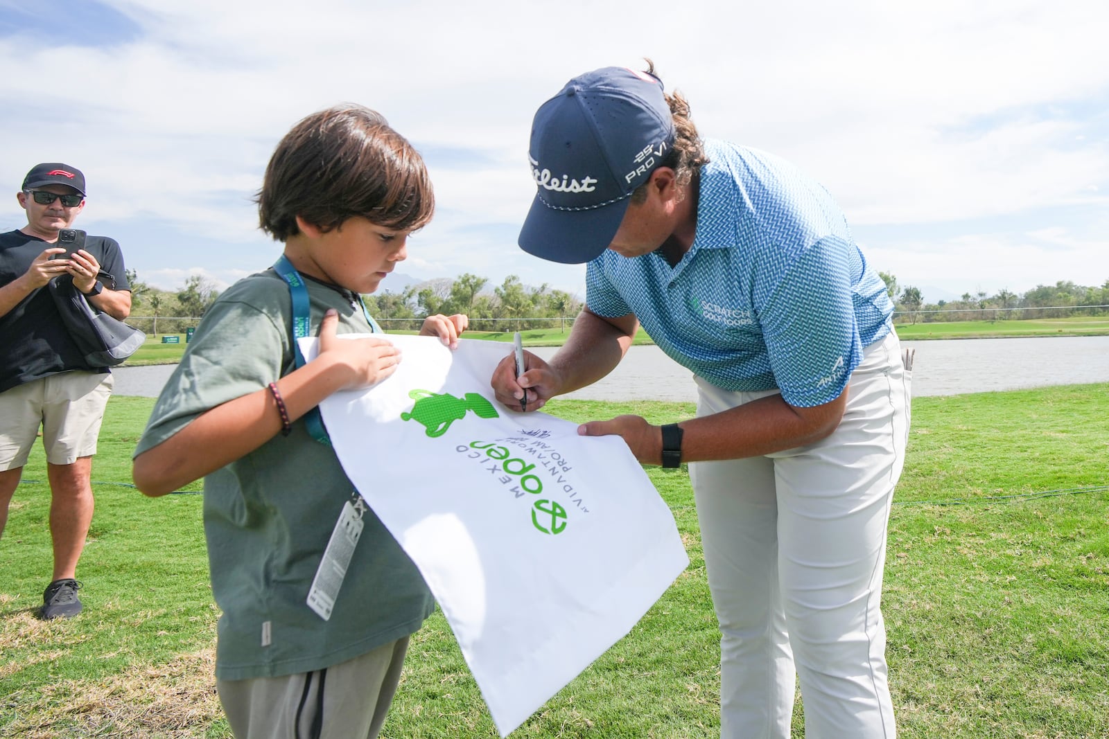 Aldrich Potgieter, of South Africa, autographs a golf flag for a fan during the third round of the Mexico Open golf tournament in Puerto Vallarta, Mexico, Saturday, Feb. 22, 2025. (AP Photo/Fernando Llano)