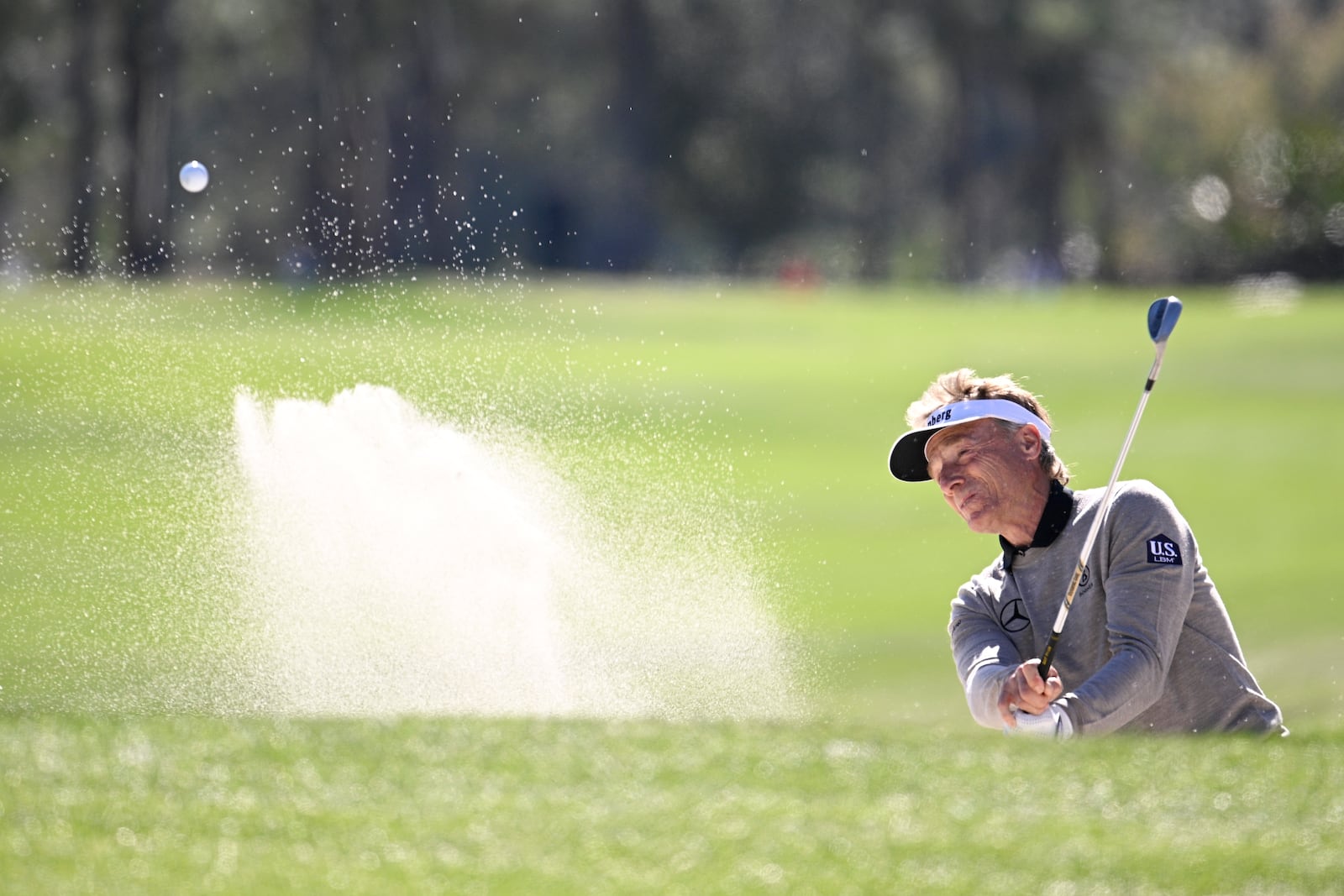 Bernhard Langer hits out of a bunker onto the third green during the final round of the PNC Championship golf tournament, Sunday, Dec. 22, 2024, in Orlando, Fla. (AP Photo/Phelan M. Ebenhack)