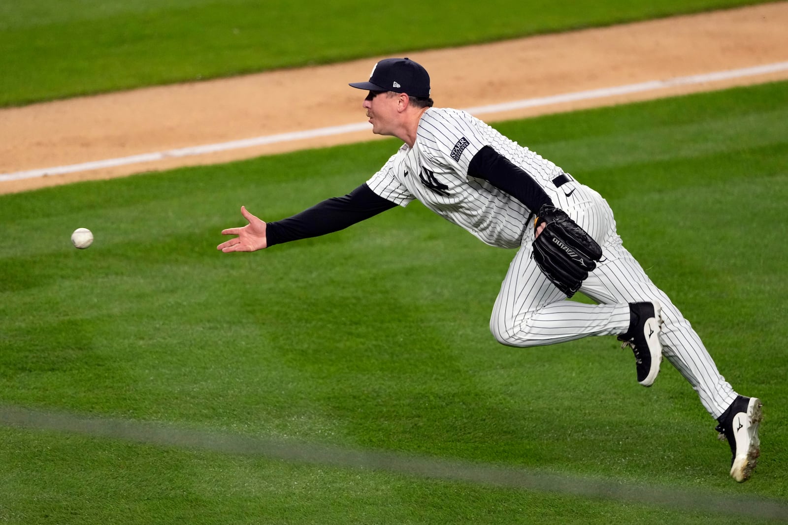 New York Yankees pitcher Mark Leiter Jr. tosses the ball to catcher Jose Trevino during the fourth inning in Game 3 of the baseball World Series, Monday, Oct. 28, 2024, in New York. Trevino tagged Los Angeles Dodgers' Gavin Lux out at home. (AP Photo/Seth Wenig)