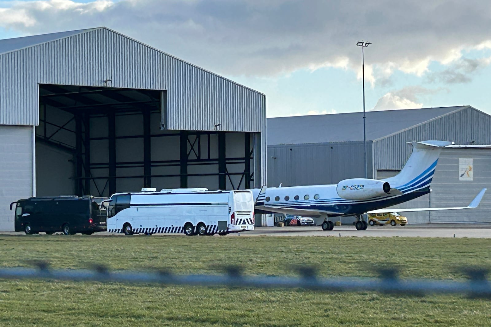 A plane believed to be carrying former Philippine President Rodrigo Duterte is parked next to a bus at Rotterdam The Hague Airport in the Netherlands, Wednesday, March 12, 2025. (AP Photo/Mark Carlson)