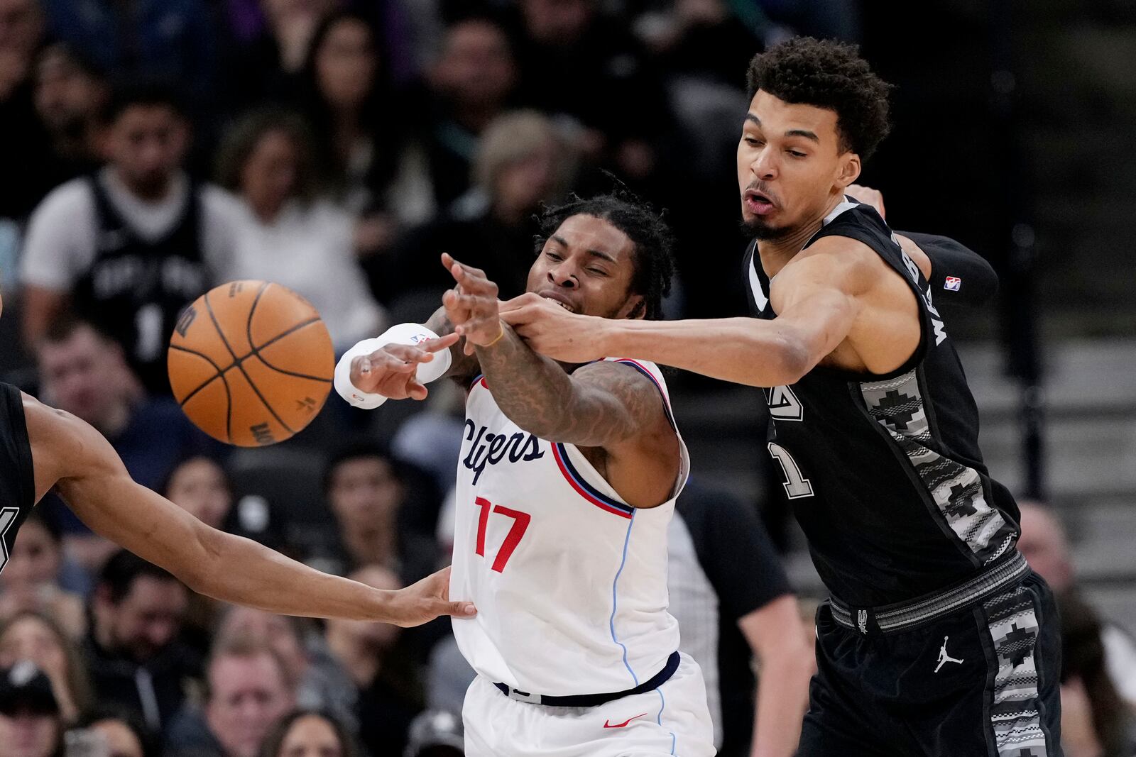 LA Clippers forward P.J. Tucker (17) and San Antonio Spurs center Victor Wembanyama chase a loose ball during the first half of an NBA basketball game in San Antonio, Wednesday, Jan. 29, 2025. (AP Photo/Eric Gay)