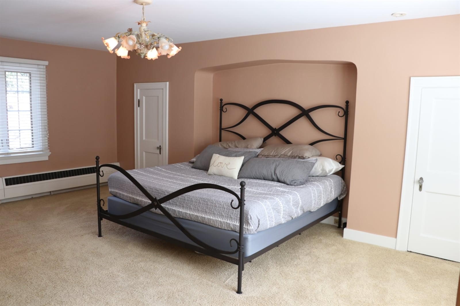 This bedroom has a furniture nook flanked by step-in closets and an electric corner fireplace. 