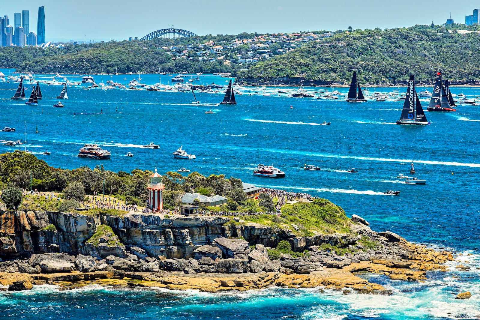 In this photo provided by Rolex, competitors sail towards the heads as they leave Sydney Harbour at the start of the Sydney to Hobart yacht race in Sydney, Thursday, Dec. 26, 2024. (Carlo Borlenghi/Rolex via AP)