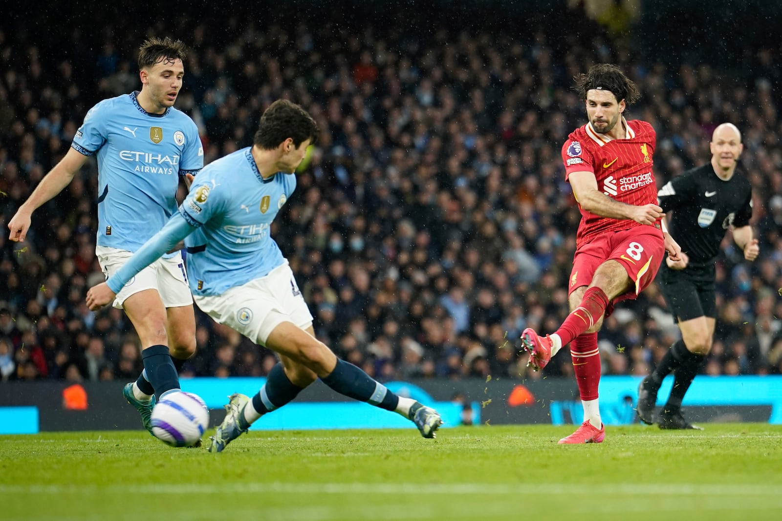 Liverpool's Dominik Szoboszlai, right, scores his side's 2nd goal during the English Premier League soccer match between Manchester City and Liverpool at Etihad stadium in Manchester, England, Sunday, Feb. 23, 2025. (AP Photo/Dave Thompson)