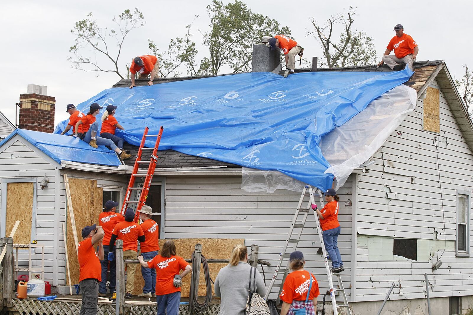 Volunteers with Samaritan’s Purse worked in this Harrison Twp. neighborhood and others that were affected by tornado damage. The workers covered this house on Maumee Avenue. TY GREENLEES / STAFF