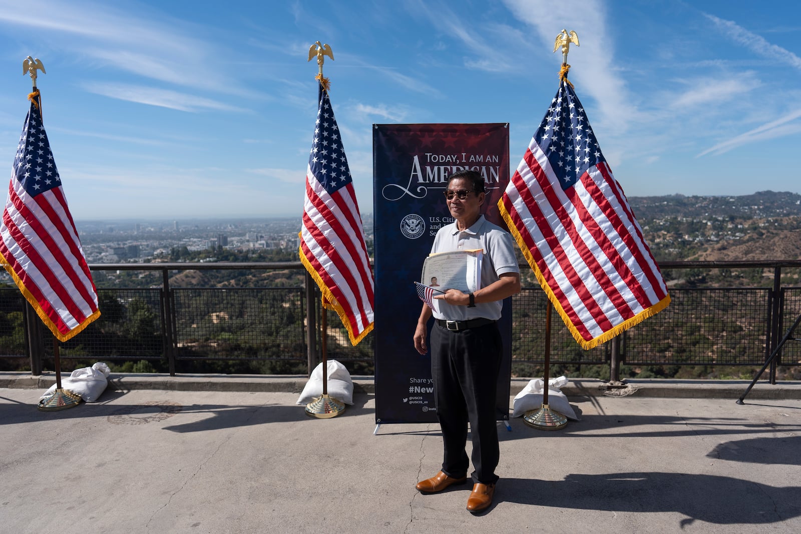 Felix Tapongot poses for photos with his certificate of citizenship following a naturalization ceremony at Griffith Observatory in Los Angeles, Monday, Oct. 21, 2024. (AP Photo/Jae C. Hong)