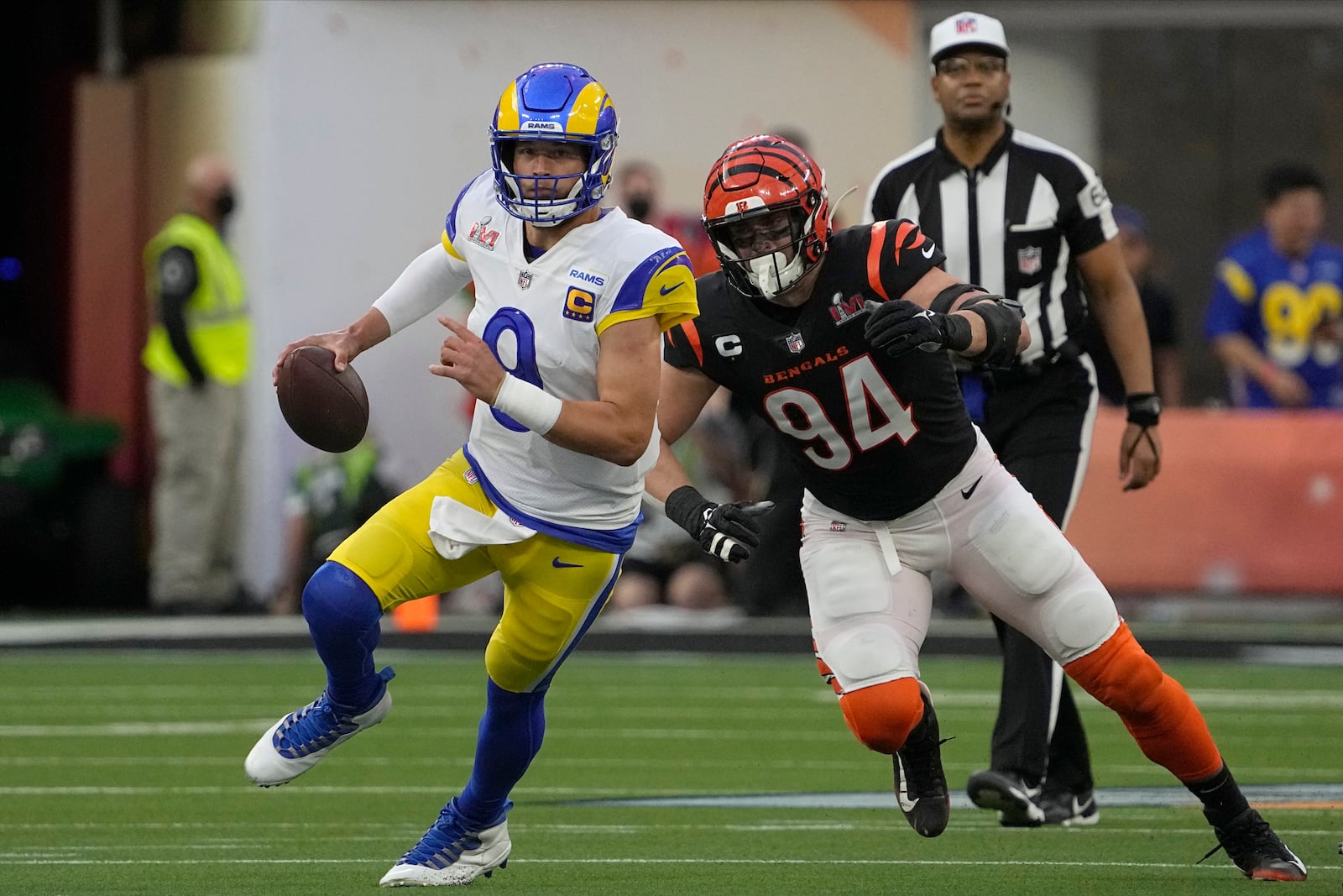 Los Angeles Rams quarterback Matthew Stafford (9) rolls out of the pocket under pressure from Cincinnati Bengals defensive end Sam Hubbard (94) during the first half of the NFL Super Bowl 56 football game Sunday, Feb. 13, 2022, in Inglewood, Calif. (AP Photo/Mark J. Terrill)