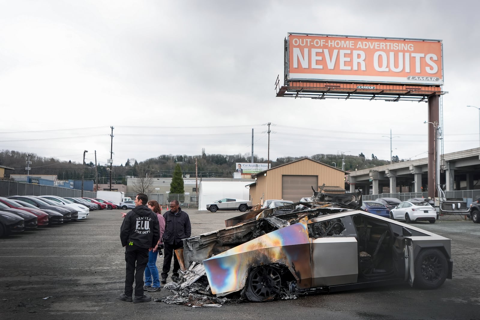 ATF investigators and a member of the Seattle Fire Department inspect burned Tesla Cybertrucks at a Tesla lot in Seattle, Monday, March 10, 2025. (AP Photo/Lindsey Wasson)