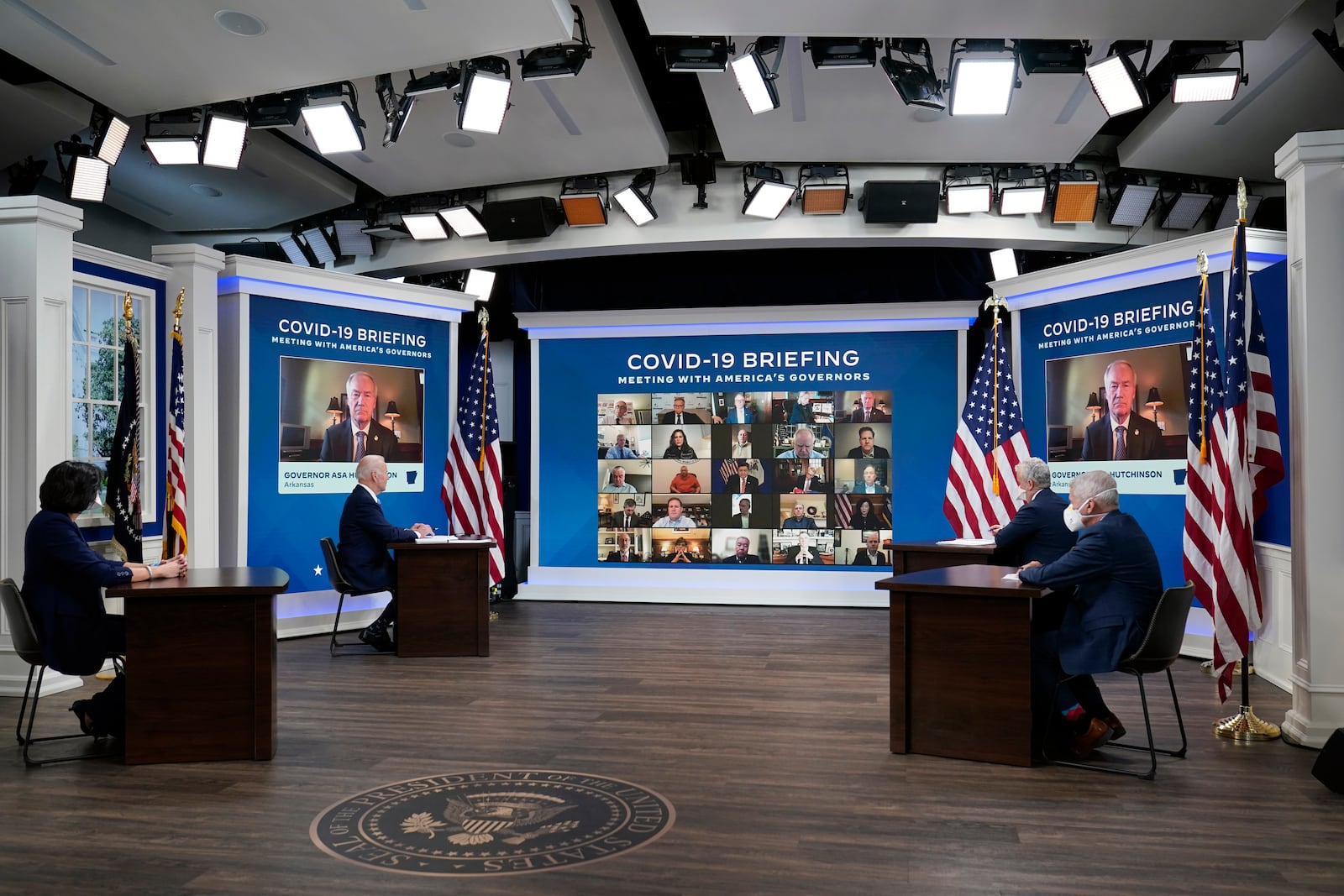 FILE - President Joe Biden, second left, participates in the White House COVID-19 Response Team's regular call with the National Governors Association in the South Court Auditorium in the Eisenhower Executive Office Building on the White House Campus, Monday, Dec. 27, 2021, in Washington. Seated with the President from left Dr. Rochelle Walensky, Director of the Centers for Disease Control and Prevention, Biden, Jeff Zients, COVID-19 Response Coordinator and Dr. Anthony Fauci, White House Chief Medical Advisor and Director of the NIAID. (AP Photo/Carolyn Kaster, File)