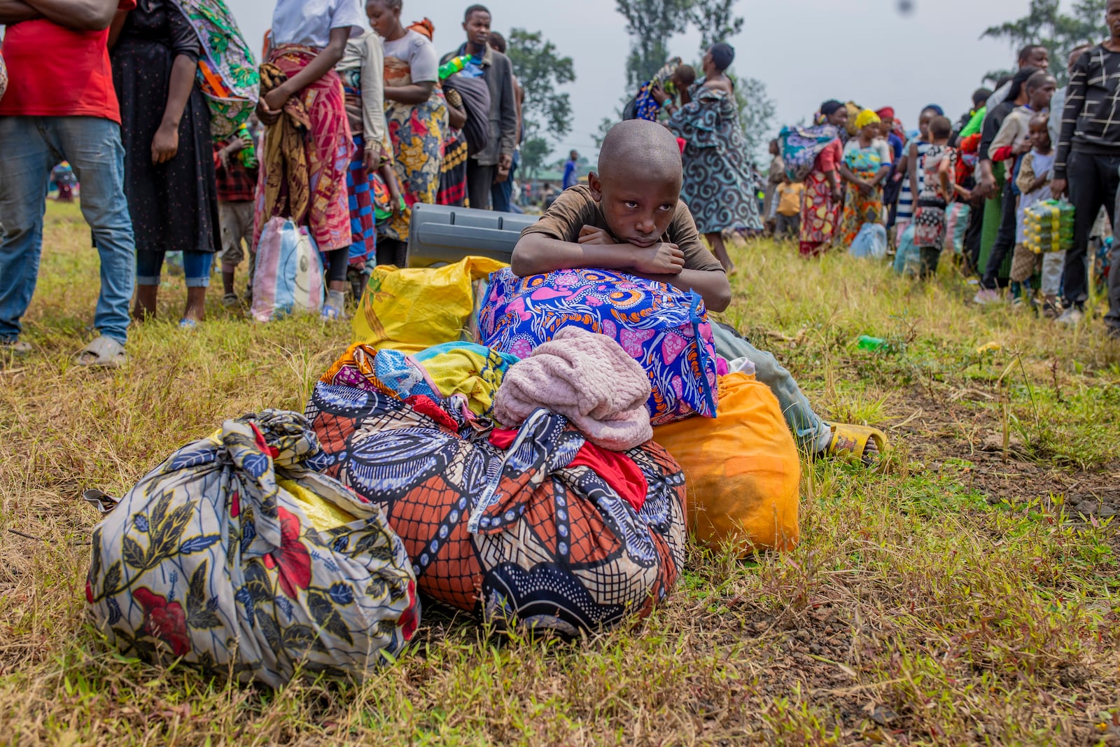 People who crossed from Congo wait for assistance in Gyseny, Rwanda, Tuesday, Jan. 28, 2025, following M23 rebels' advances into eastern Congo's capital Goma. (AP Photo/Yuhi Irakiza)