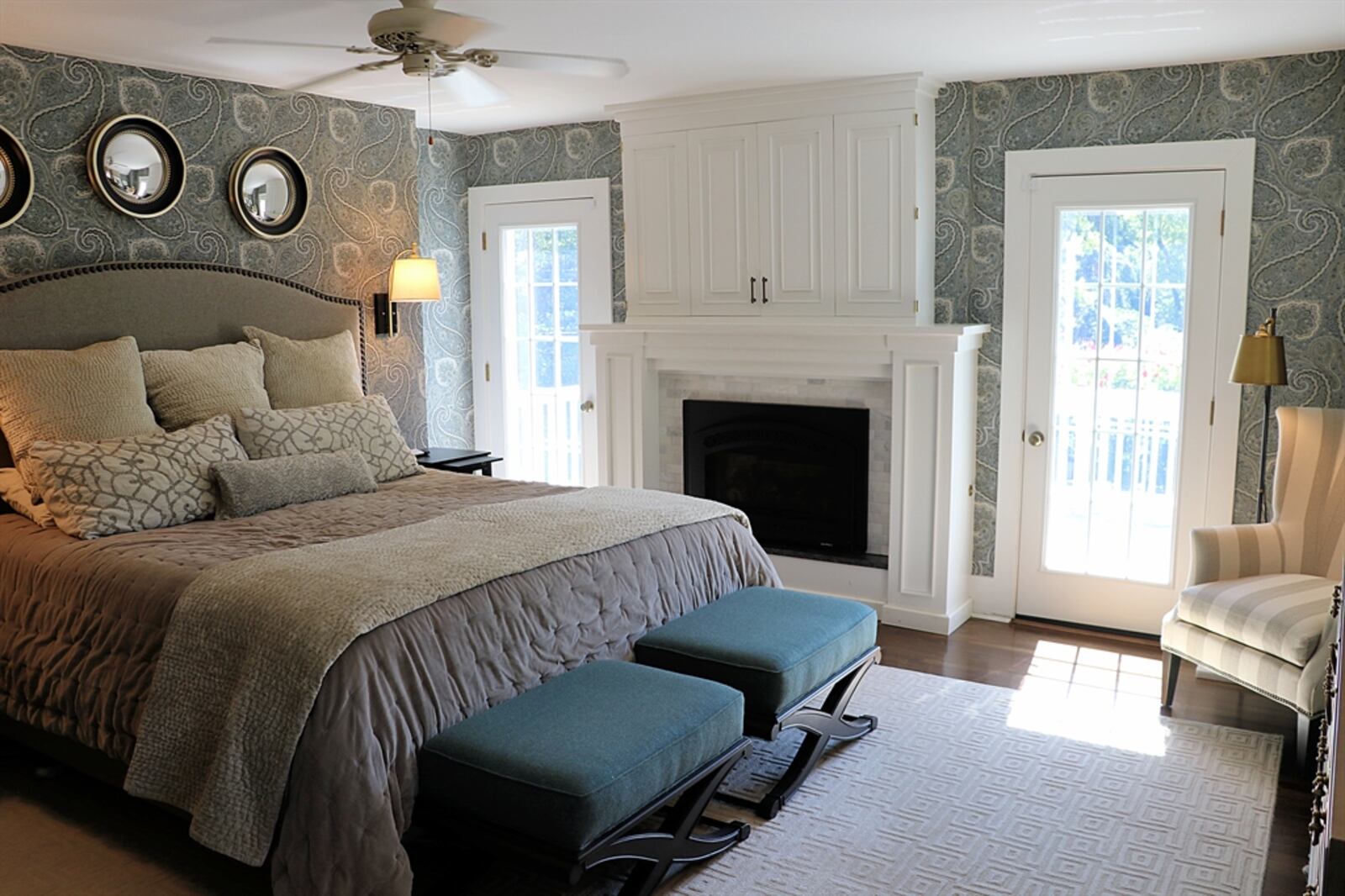 In the primary bedroom, the fireplace is flanked by glass doors that open to a balcony deck with terrace garden views. Contributed by Kathy Tyler