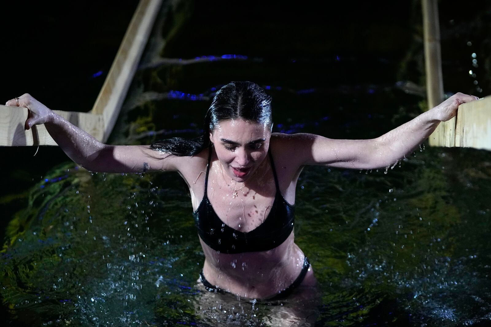 A woman pauses while plunging herself in icy waters to celebrate the Orthodox Epiphany at the Izmailovsky Kremlin in Moscow, Russia, Saturday, Jan. 18, 2025. (AP Photo/Pavel Bednyakov)