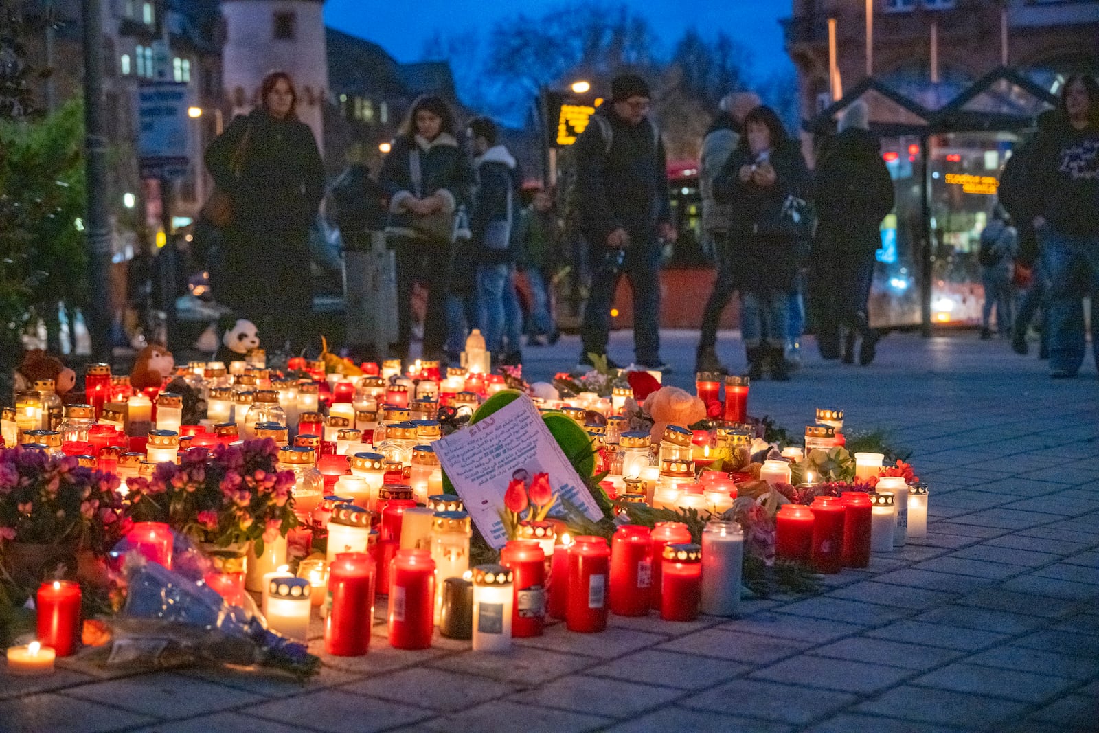 Numerous candles are placed in Aschaffenburg, Germany, Thursday, Jan. 23, 2025 following the fatal attack in a park. (Daniel Vogl/dpa via AP)