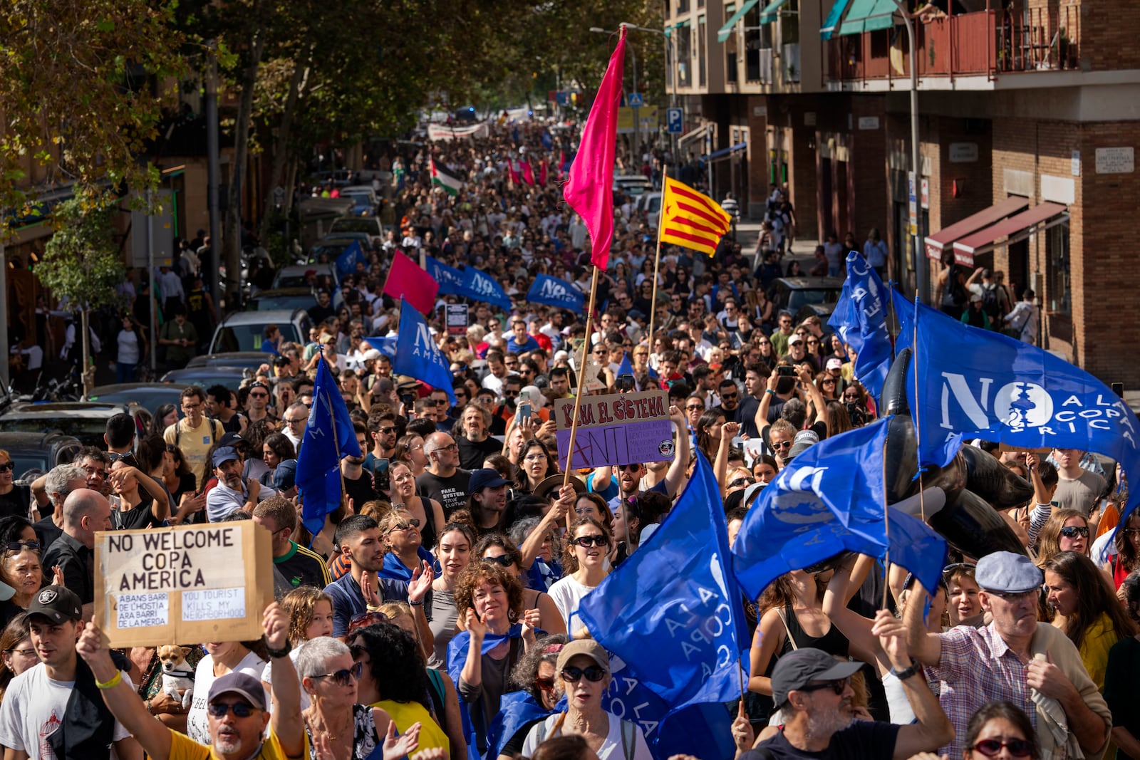 Demonstrators march shouting slogans against the holding of the America's Cup sailing competition, during a protest demanding the right to housing, in Barcelona, Spain, Sunday, Oct. 13, 2024. (AP Photo/Emilio Morenatti)