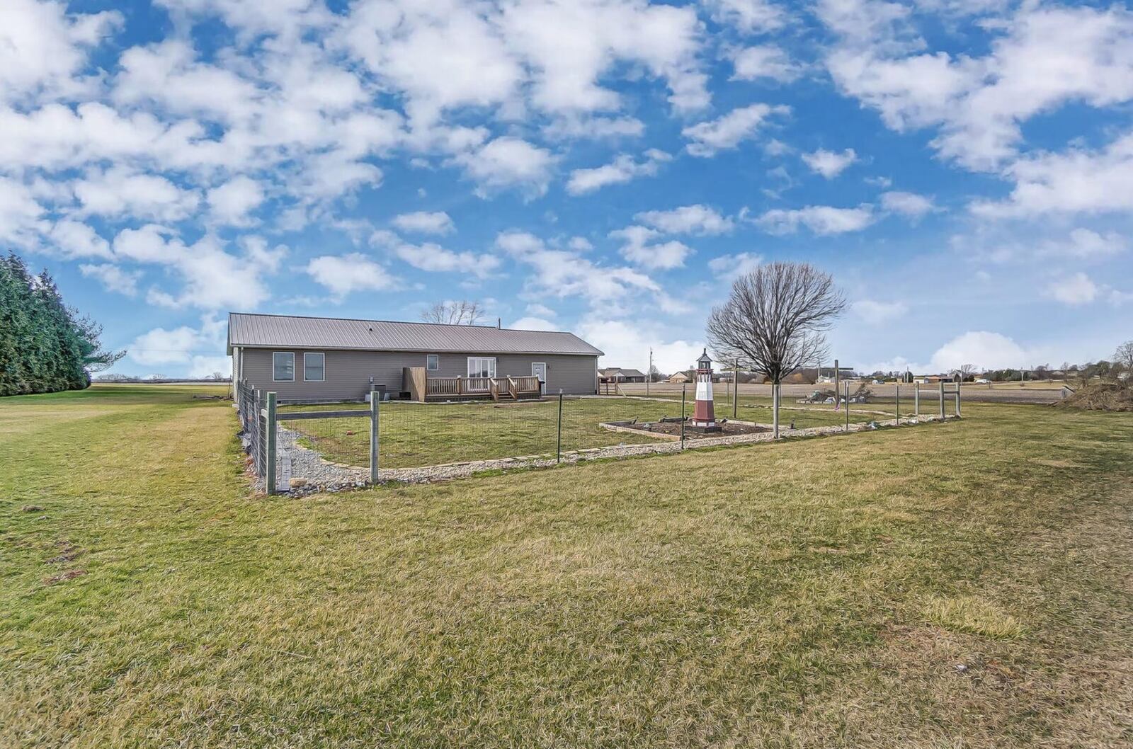 The rear yard is partially fenced, has two wood decks and overlooks farmland.