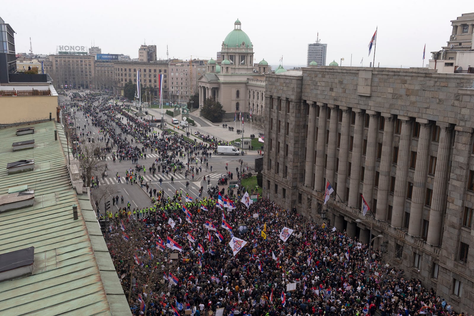 Protesters gather close to the Serbian parliament, background, during a major anti-corruption rally led by university students in Belgrade, Serbia, Saturday, March 15, 2025. (AP Photo/Marko Drobnjakovic)