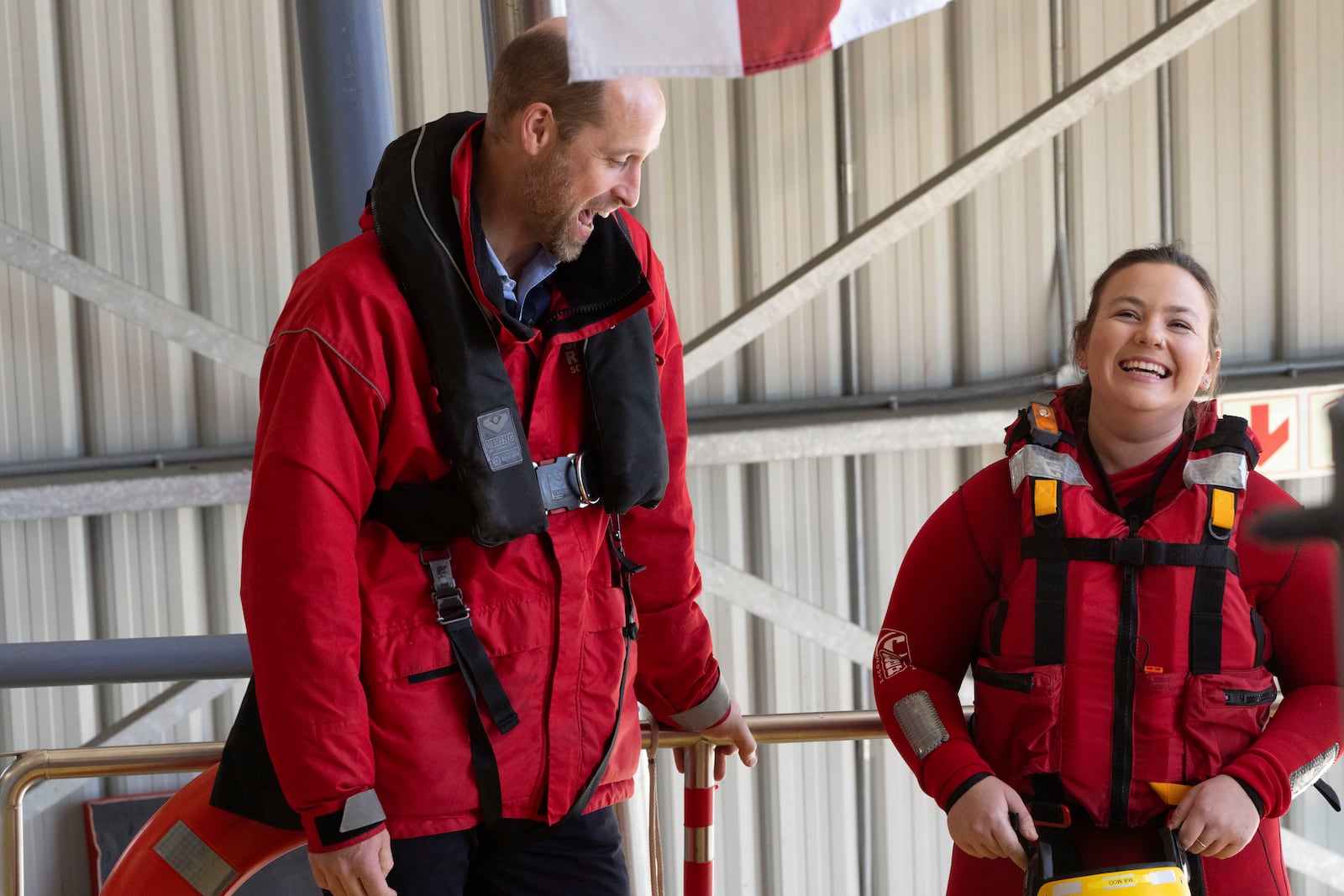 Britain's Prince William shares a laugh with one of the volunteers of the National Sea Rescue Initiative near Simon's Town harbour, in Cape Town, South Africa, Thursday, Nov. 7, 2024. (AP Photo/Jerome Delay, Pool)