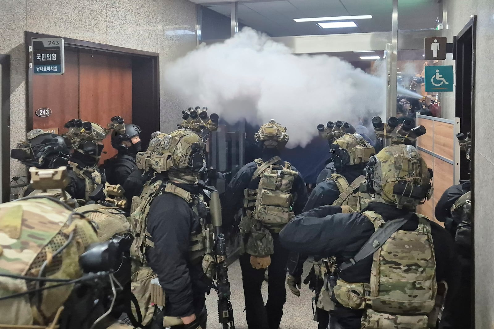 National Assembly employees spray a fire extinguisher towards soldiers at the National Assembly in Seoul, South Korea, Wednesday, Dec. 4, 2024. (Cho Da-un/Yonhap via AP)