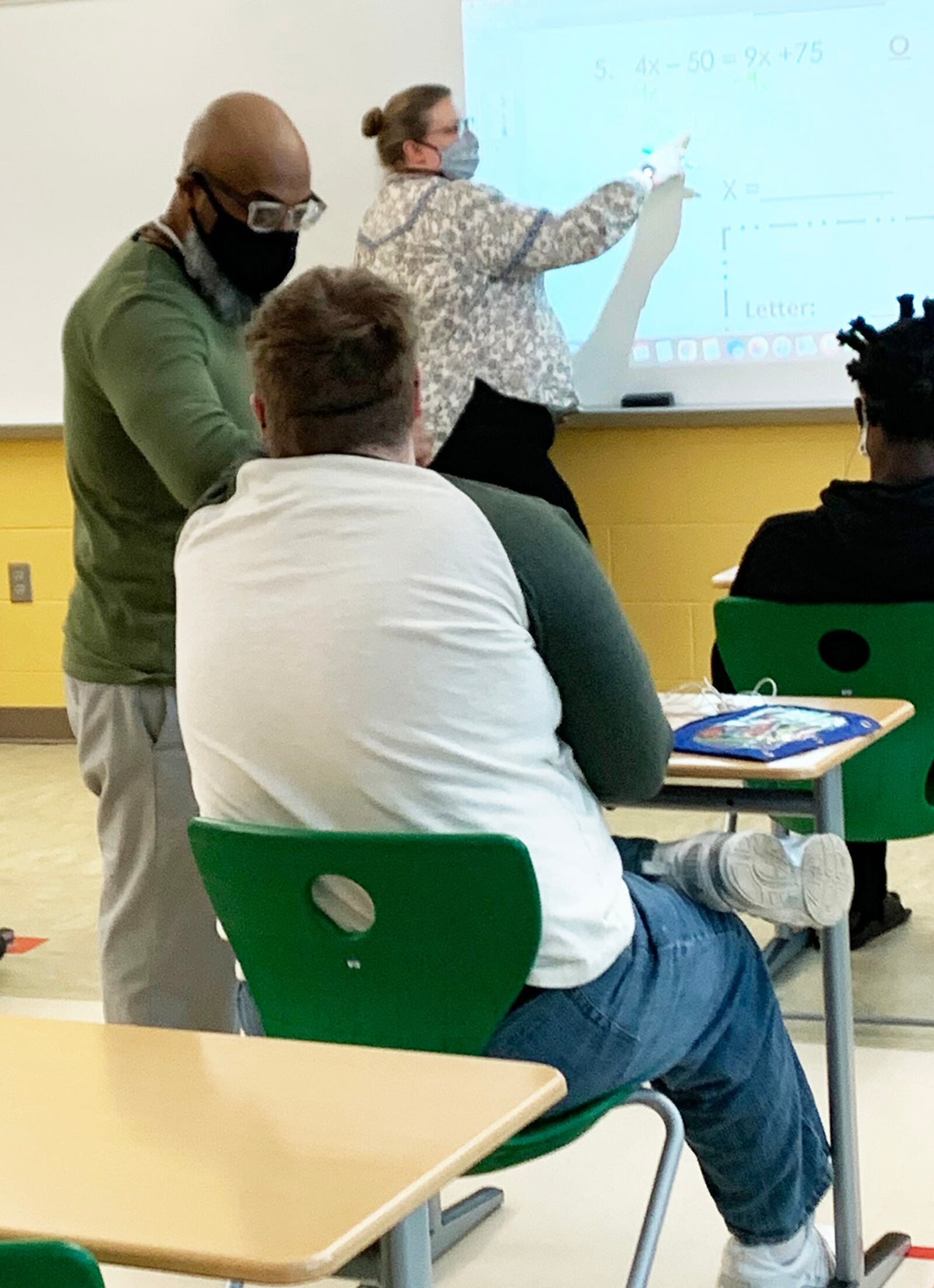 Northmont paraprofessional Kenny Carpenter helps a student check the steps of an algebra problem as classroom instructor Jessica Pahl takes the class through a multi-step problem. CONTRIBUTED