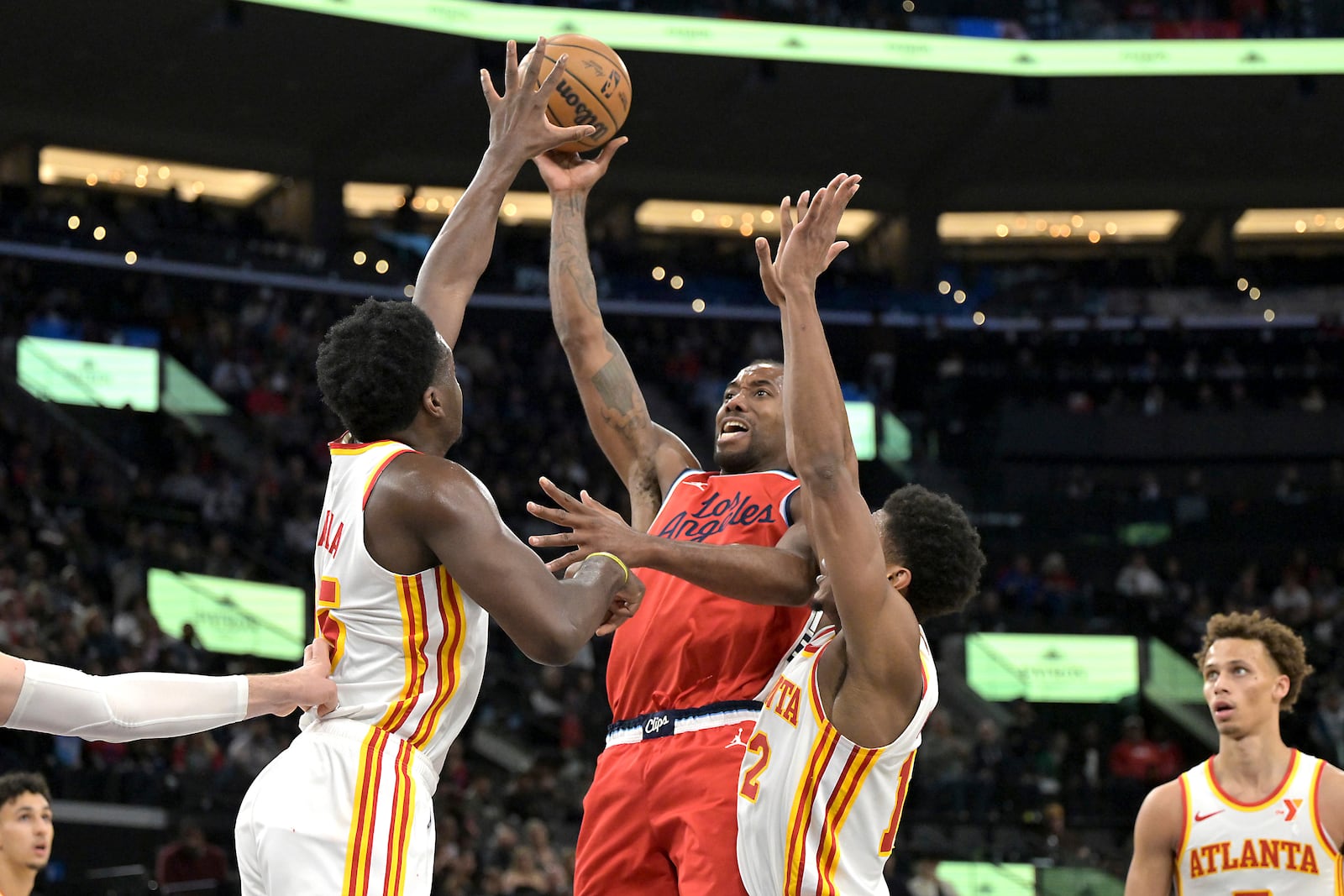 Los Angeles Clippers forward Kawhi Leonard, center, is defended by Atlanta Hawks center Clint Capela, left, and Hawks forward De'Andre Hunter during the second half of an NBA basketball game Saturday, Jan. 4, 2025, in Los Angeles. (AP Photo/Jayne-Kamin-Oncea)