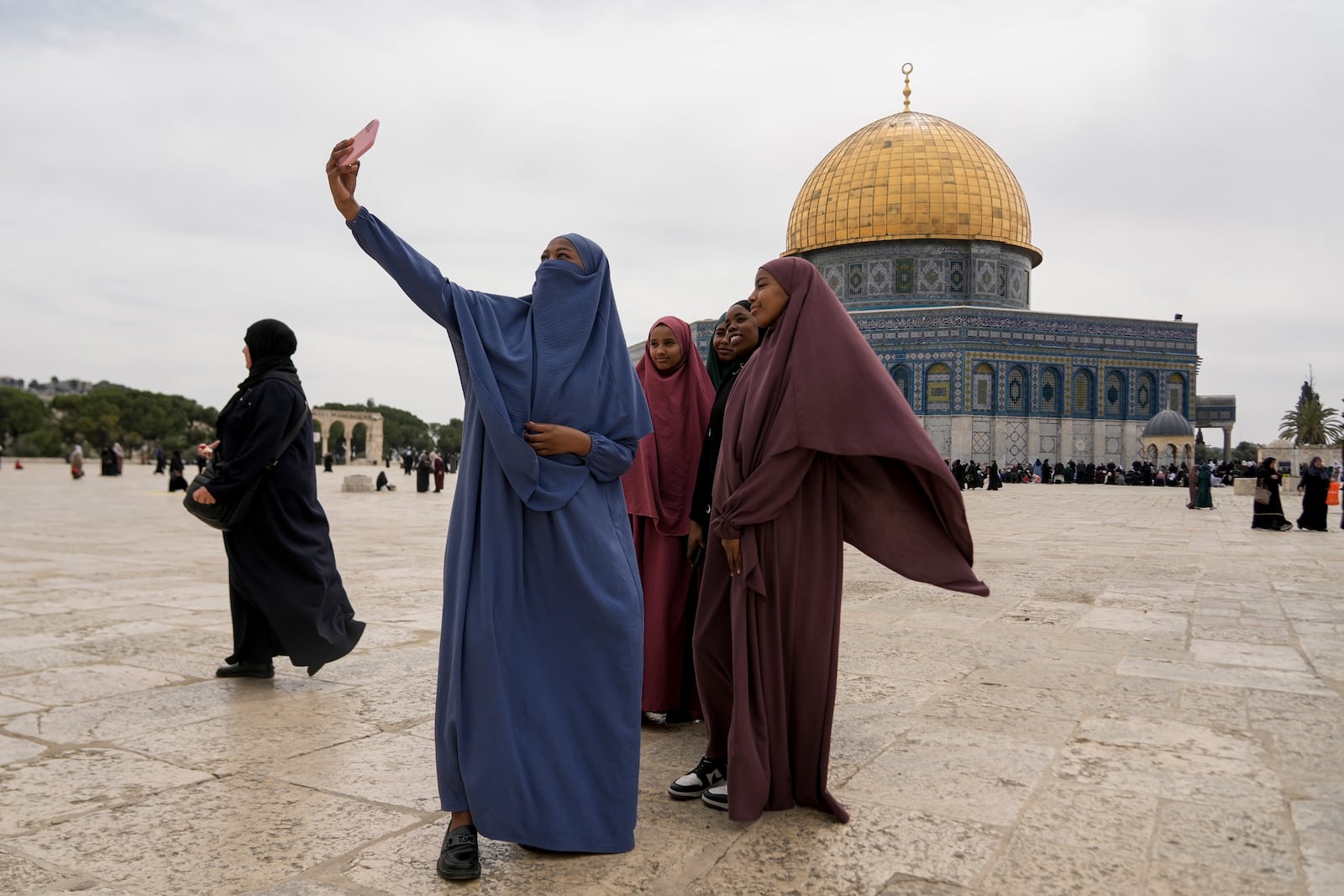 Palestinian women take a photo next to the the Dome of the Rock shrine at the Al-Aqsa Mosque compound in the Old City of Jerusalem, during the Muslim holy month of Ramadan, Friday, March 14, 2025. (AP Photo/Mahmoud Illean)