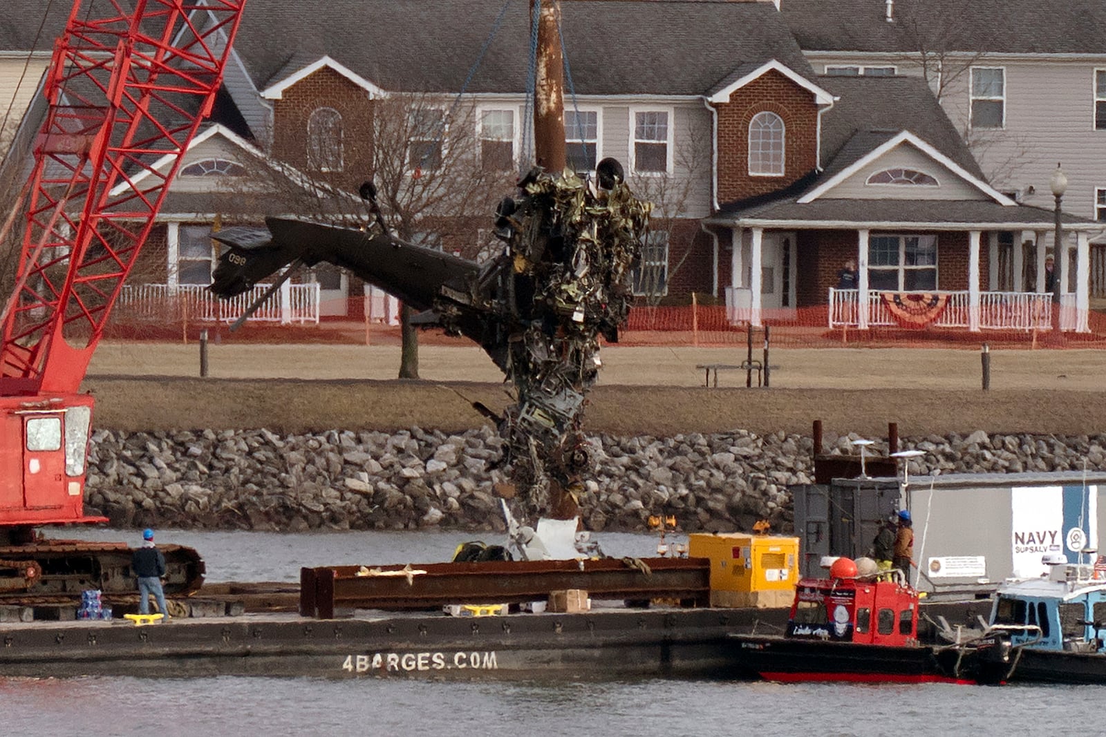 Salvage crews pull up a part of a Black Hawk helicopter near the site in the Potomac River of a mid-air collision between an American Airlines jet and a Black Hawk helicopter at Ronald Reagan Washington National Airport, Thursday, Feb. 6, 2025, in Arlington, Va. (AP Photo/Jose Luis Magana)