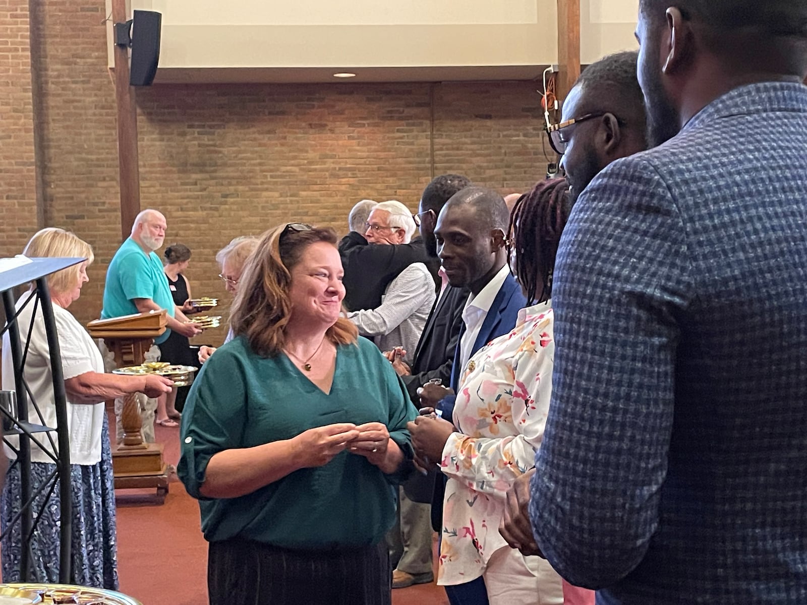 A Central Christian Church attendee greets Haitian congregation members in Springfield Sunday morning.